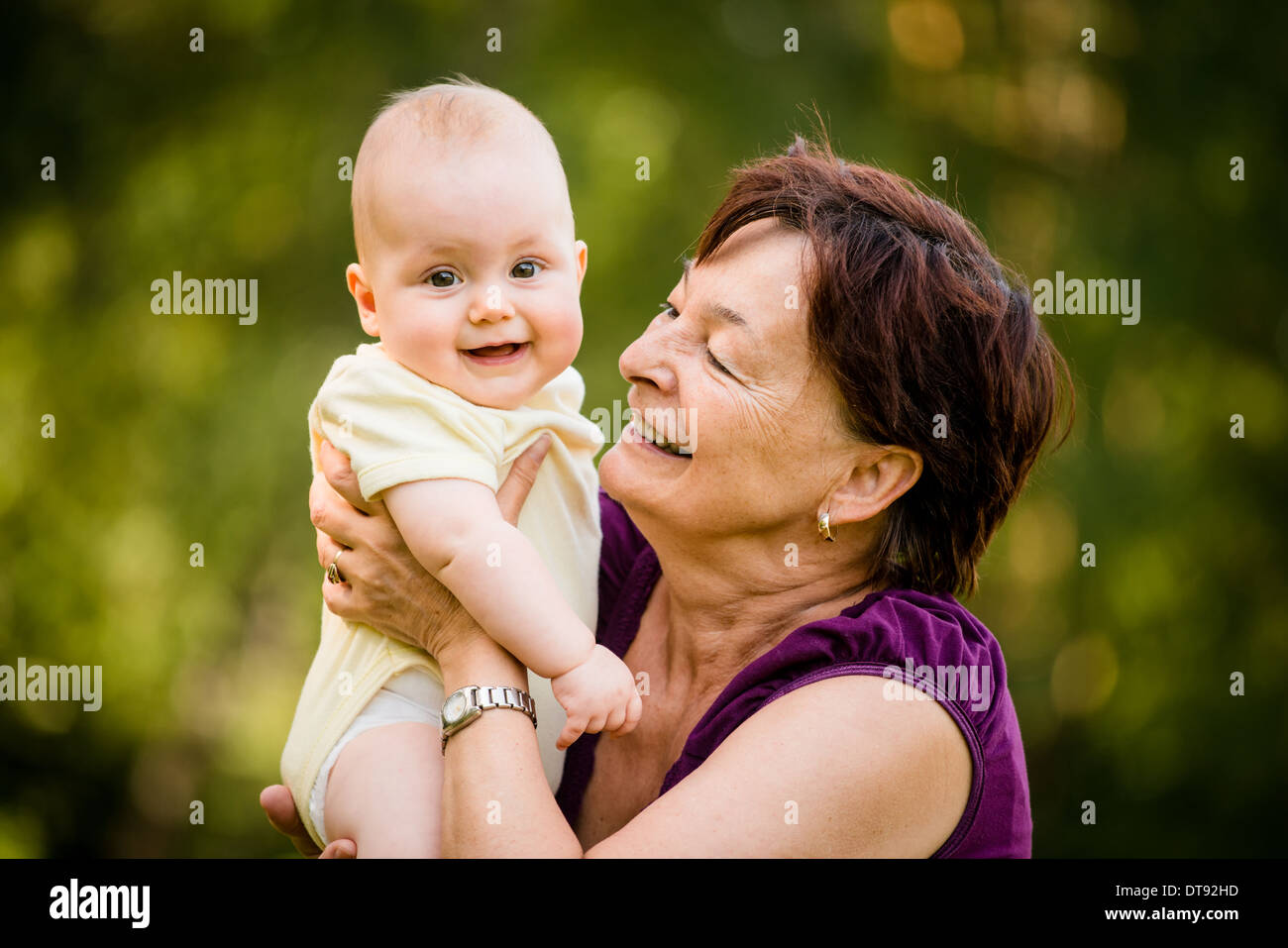 Großmutter mit Enkel - senior Frau hält ihre Enkelin im Freien in der Natur Stockfoto