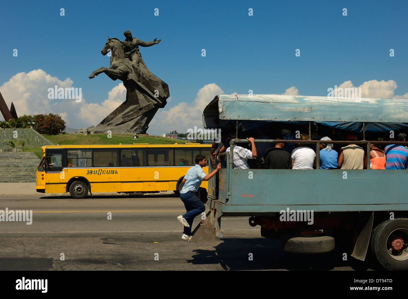Ein Mann Boards eine sich bewegende Menschen tragen Fahrzeug außerhalb der Plaza De La Revolucion. Statue von Antonio Maceo. Santiago de Cuba, Kuba Stockfoto
