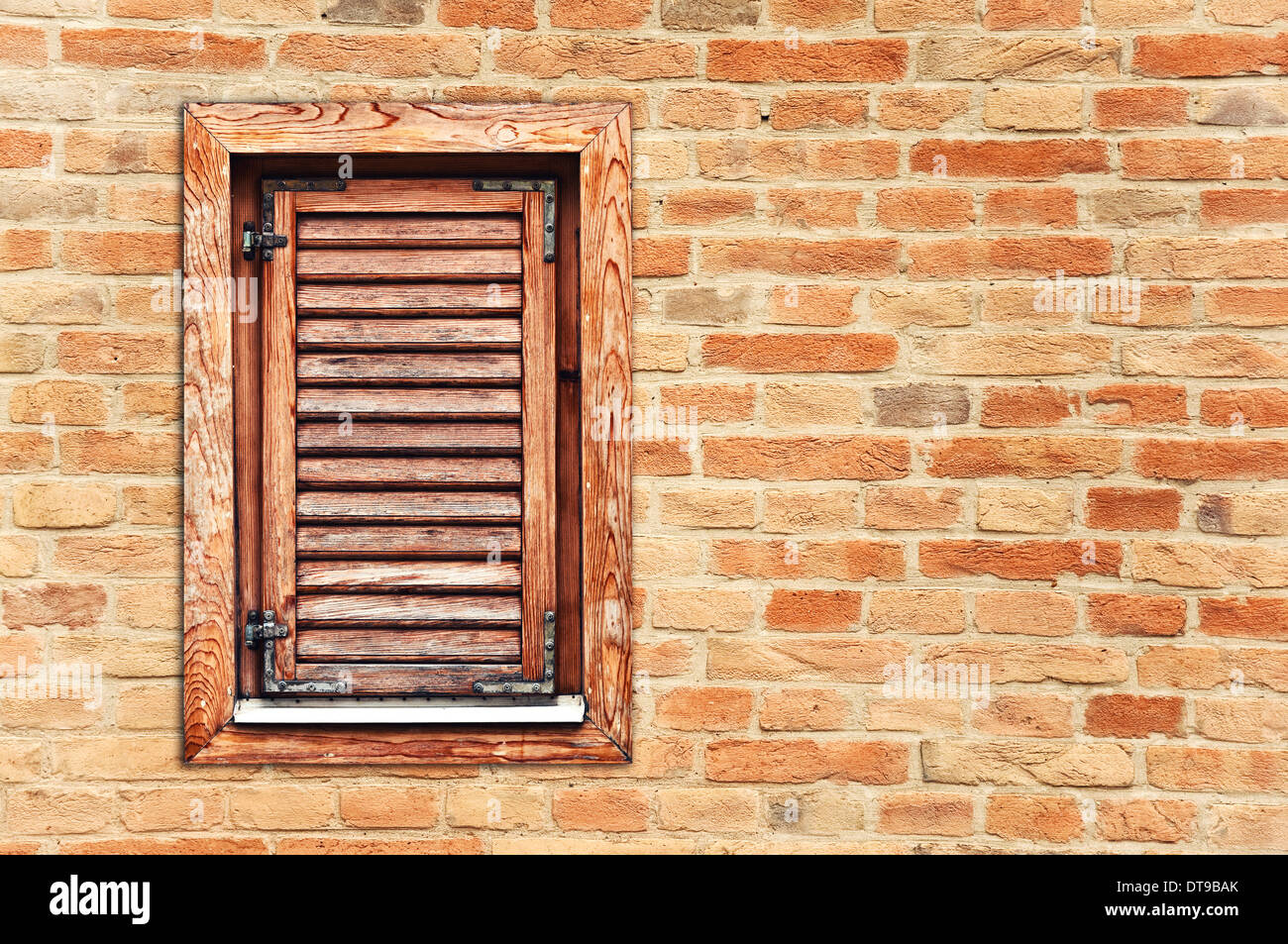 Italienischen Stil Holzfenster mit geschlossenem Verschluss Blinds auf Ziegelmauer Stockfoto