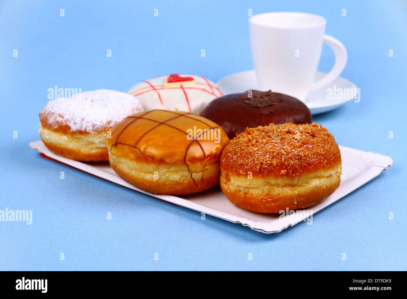 Fünf köstliche, verschiedene Donuts mit Kaffeetasse, Nahaufnahme Stockfoto