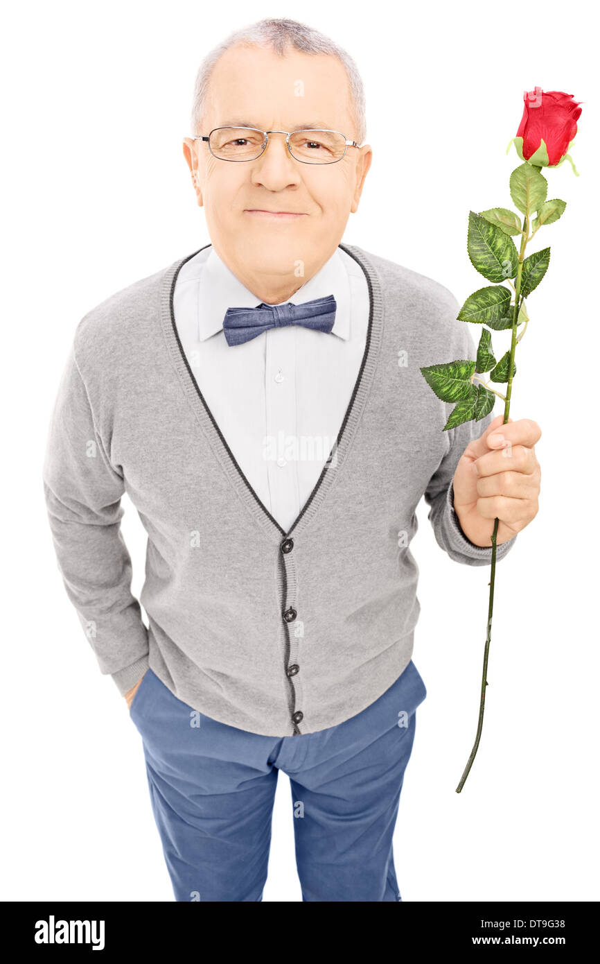 Romantische senior Gentleman hält eine Rose und Blick in die Kamera Stockfoto