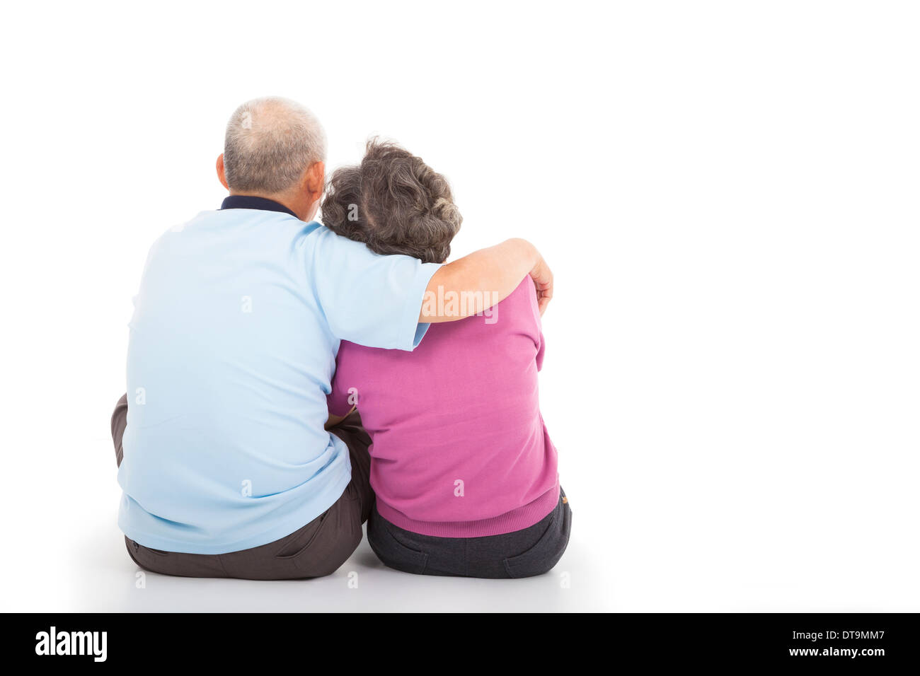 Älteres Paar glücklich Nähe auf dem Boden sitzend, auf weißem Hintergrund Stockfoto