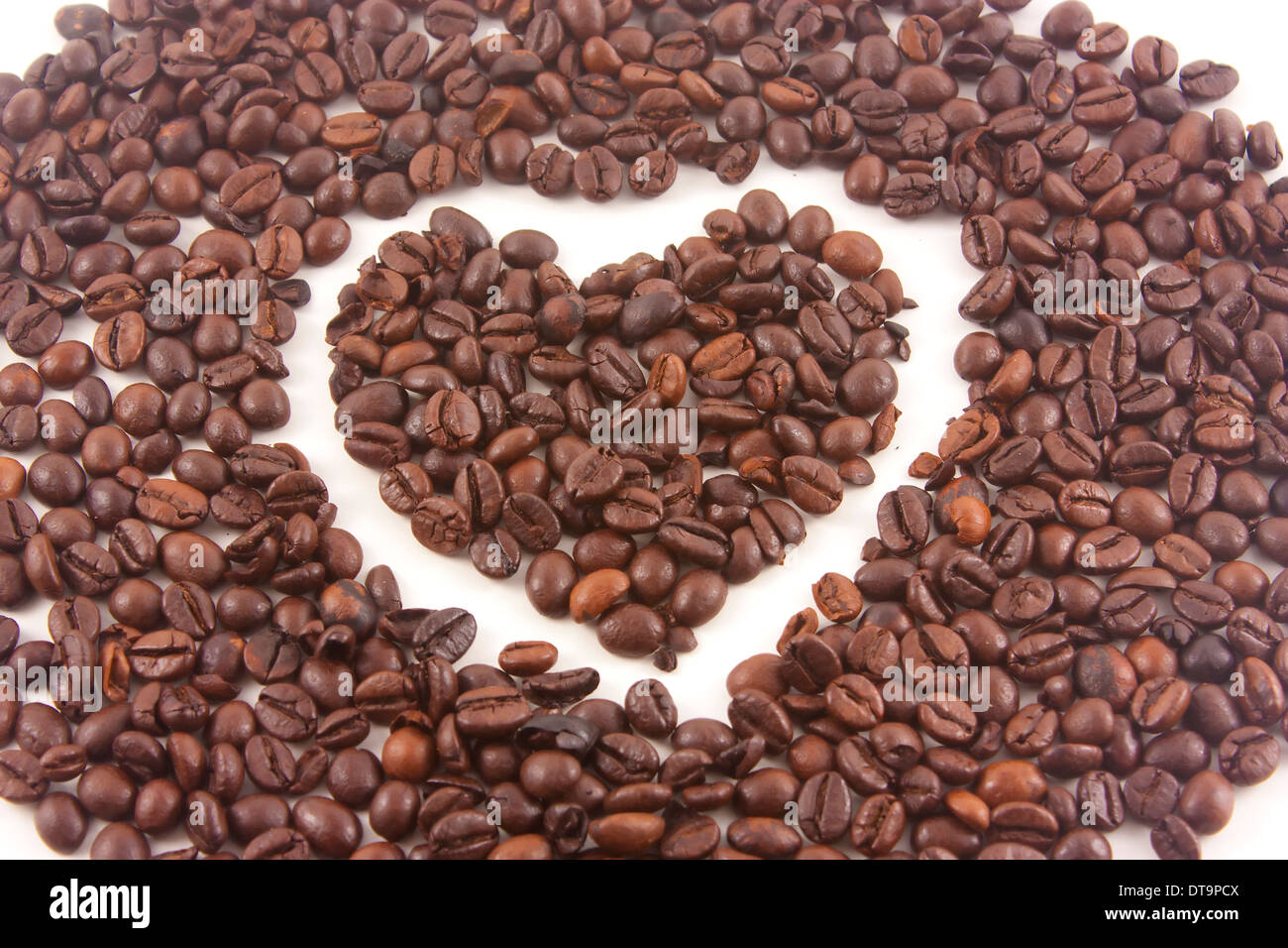 Geröstete Kaffeebohnen Herz auf weißem Hintergrund Stockfoto