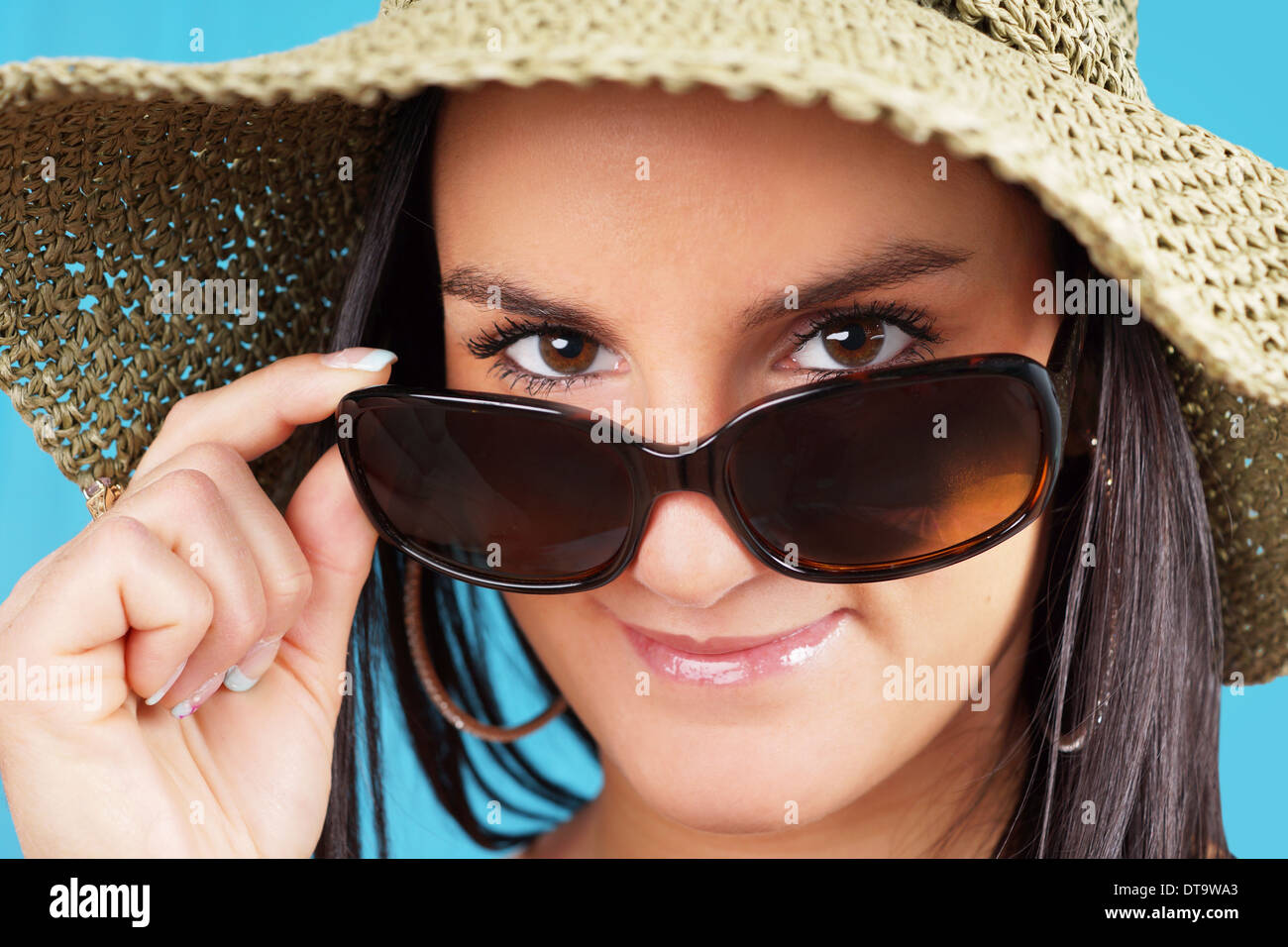 Junge Frau mit Blick auf ihre Sonnenbrille Stockfoto