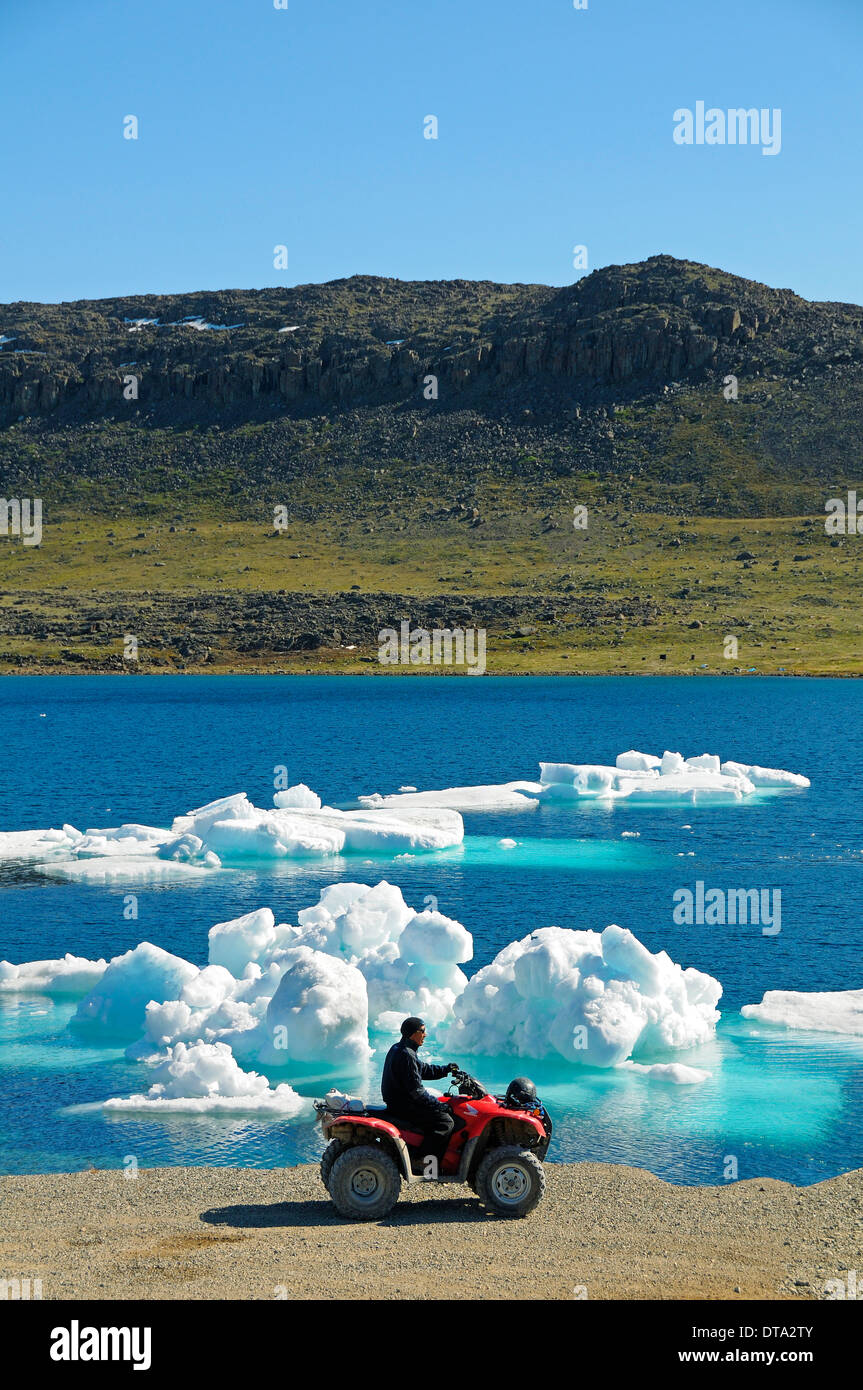 Mann des Inuit-Volkes Reiten ein Quad-Bike, ATM, parkte am Ufer der Beaufortsee, Nordpolarmeer, Victoria-Insel Stockfoto