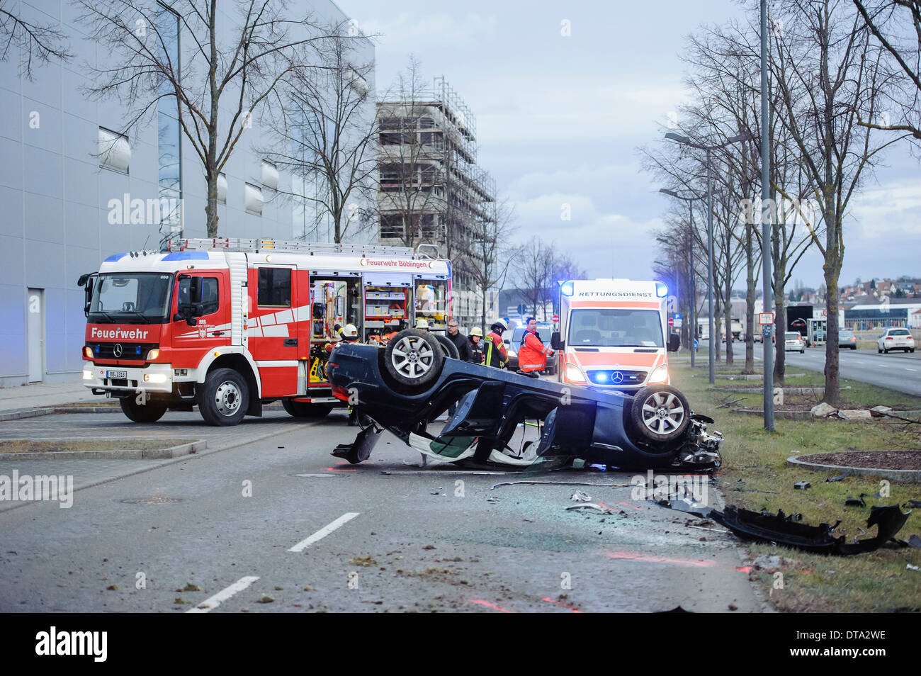 Krankenwagen und ein Feuerwehrauto an einer Unfallstelle, BMW-Sportwagen auf dem Dach umgeworfen Auto, Deutschland Stockfoto