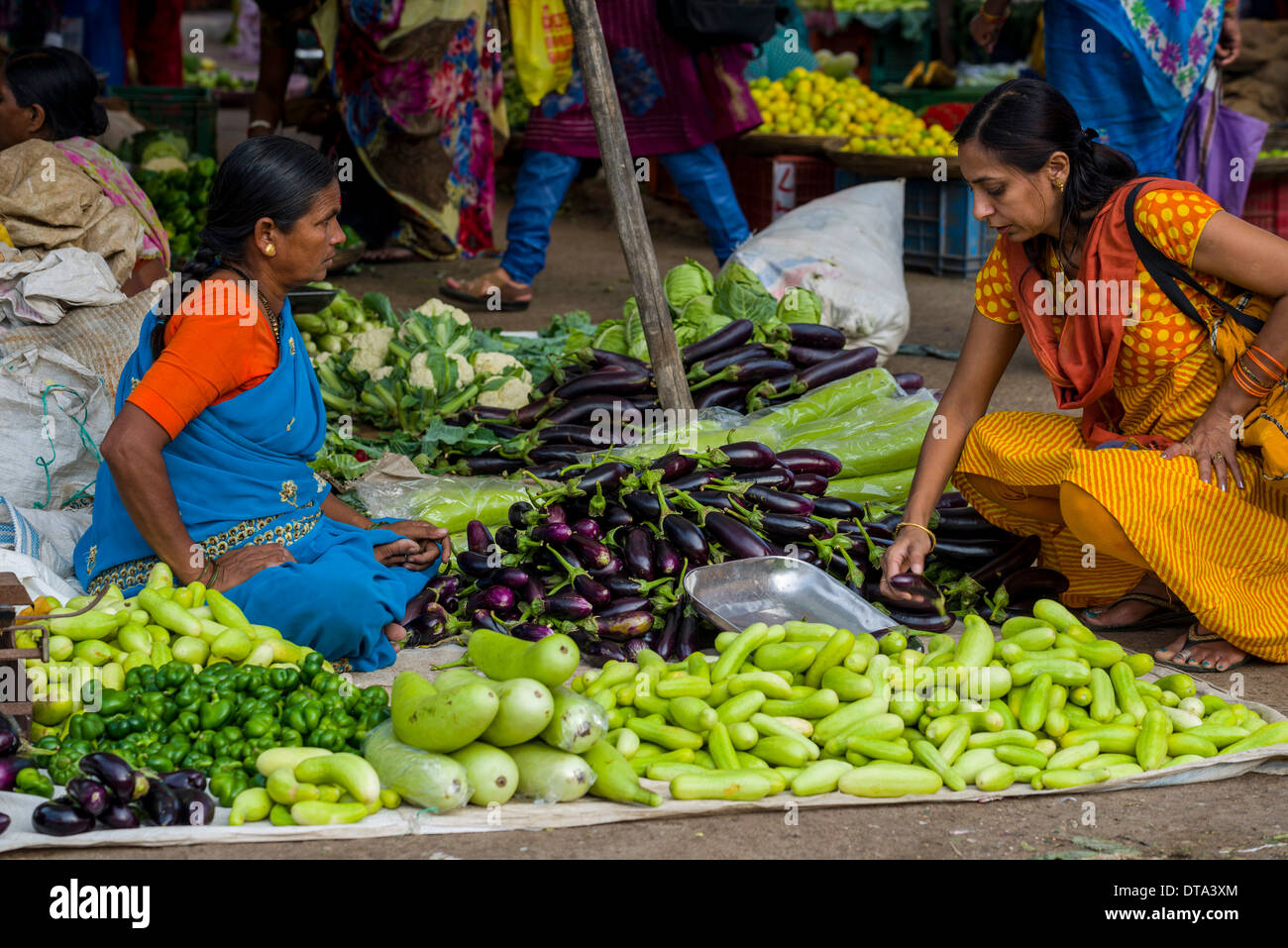 Eine Frau verkauft Auberginen, Paprika, Blumenkohl und Gurken auf dem Wochenmarkt Gemüse Nasik, Maharashtra, Indien Stockfoto