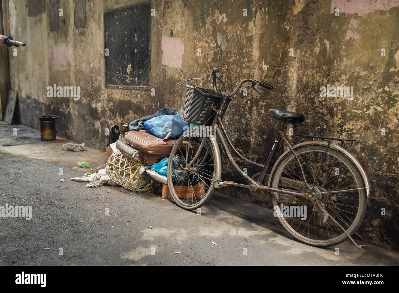 Ein altes Fahrrad in einer schmutzigen Gasse links Stockfoto