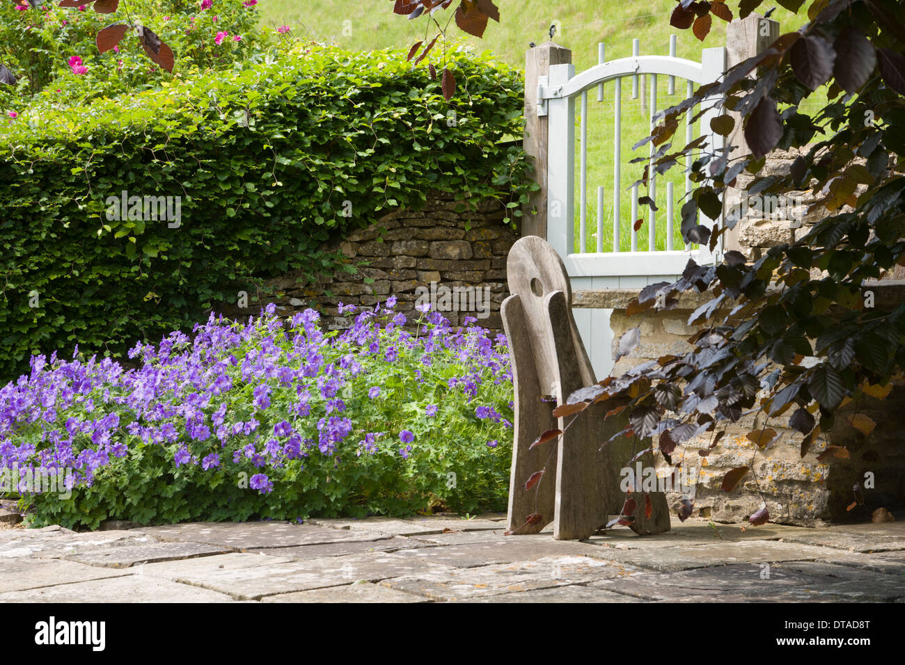 Britische Gärten. Hübscher Garten Ecke mit einem Handwerk stil Holz garten Stuhl. Stockfoto