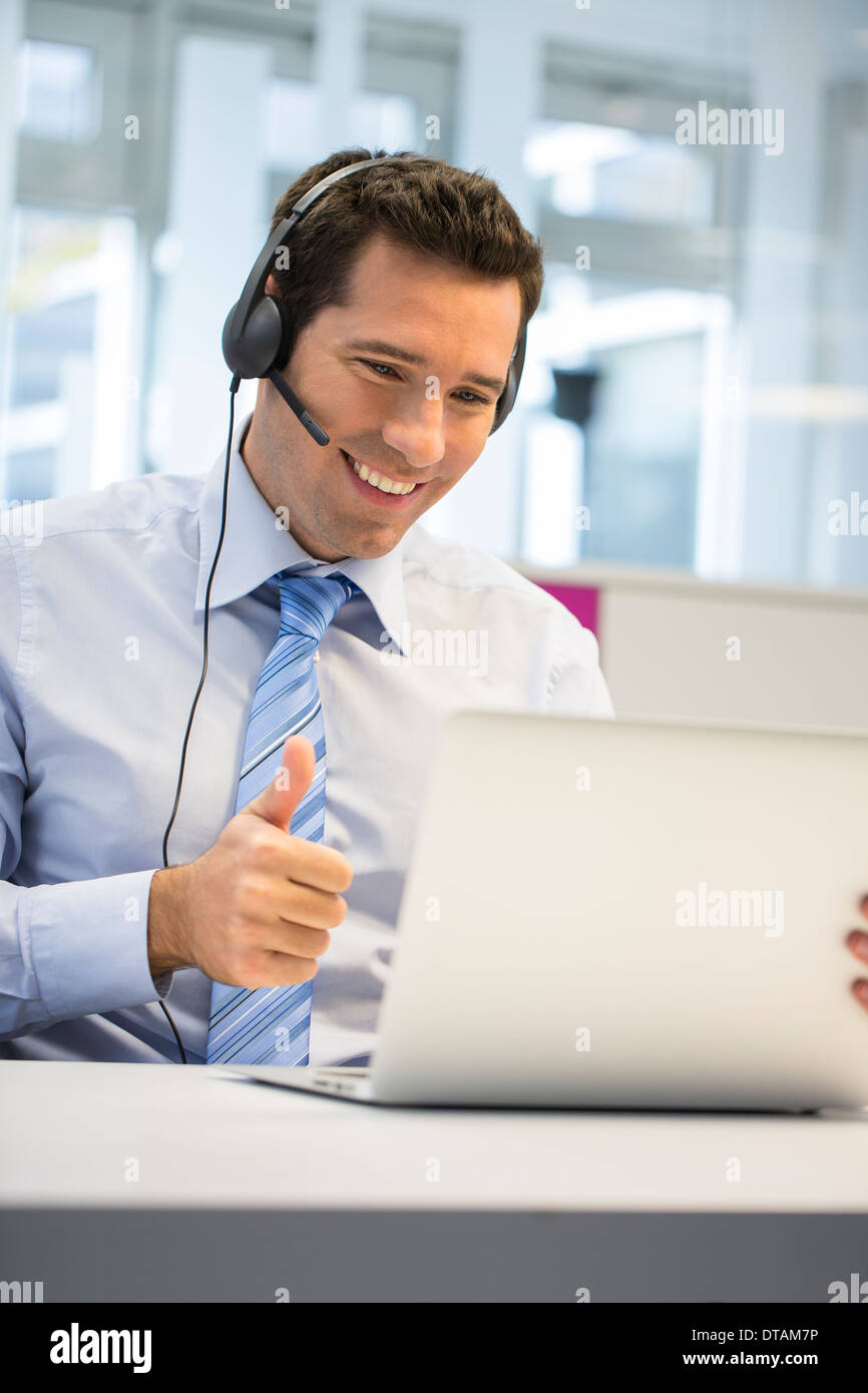 Geschäftsmann im Büro am Telefon mit Kopfhörer, Skype Stockfoto