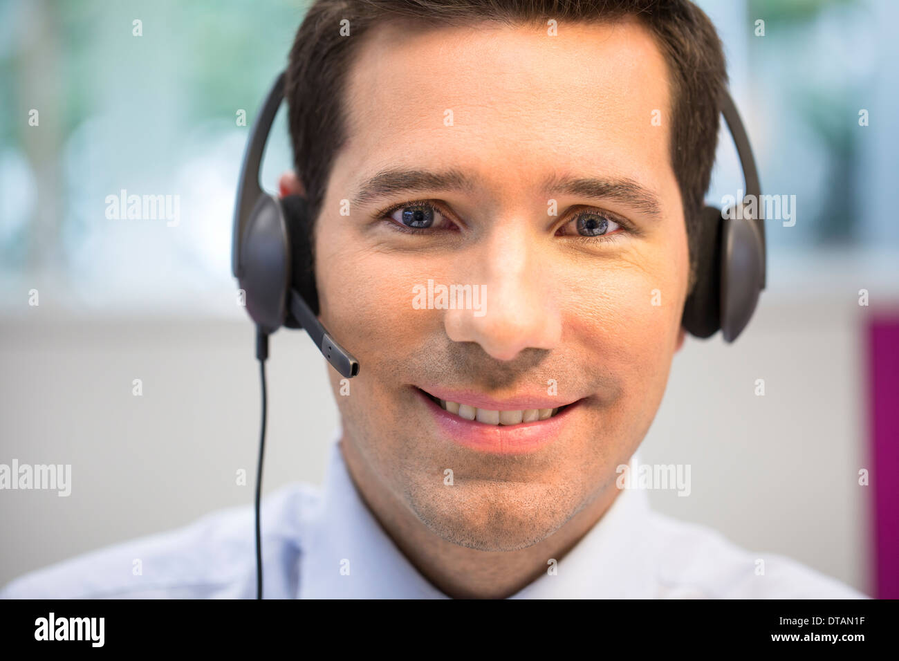 Porträt der Geschäftsmann im Büro am Telefon mit Kopfhörer, Kamera suchen Stockfoto