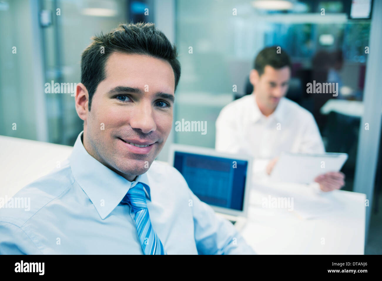Porträt von lächelnd Geschäftsmann im Büro, auf der Kamera Suche Stockfoto