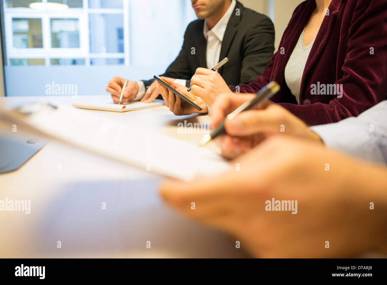 Nahaufnahme der Geschäftsfrau Hände schreiben auf TabletPC während eines Meetings Stockfoto