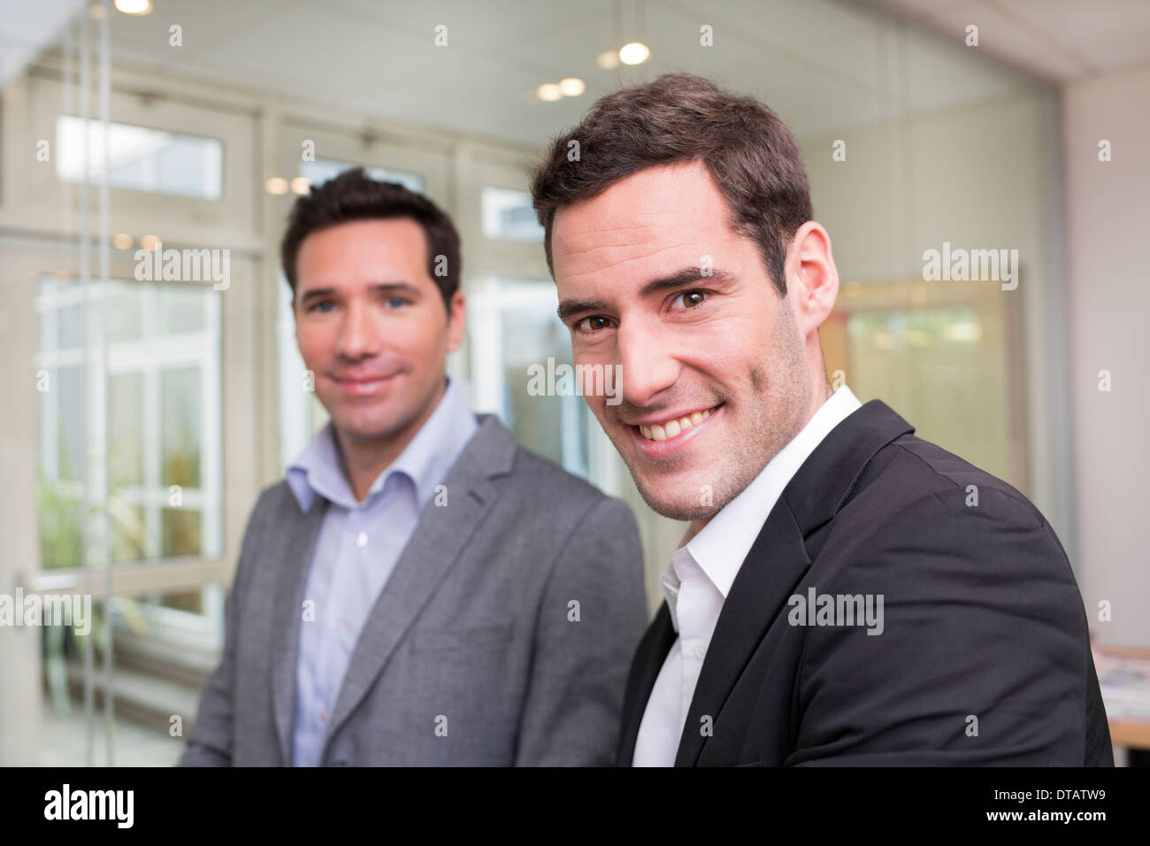 Porträt von zwei Lächeln Geschäftsleute im Büro, auf der Suche nach Kamera Stockfoto