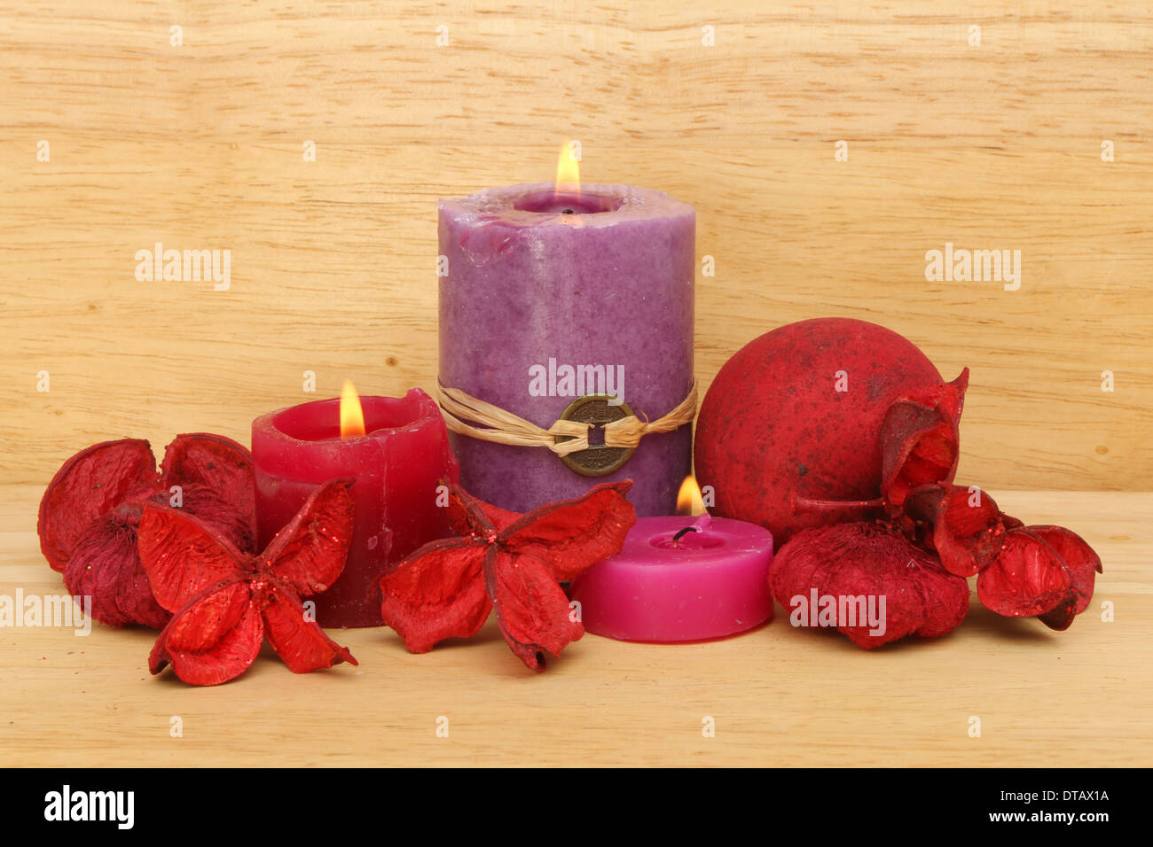 Brennende Kerzen und roten Potpourri auf einem Hintergrund von warmen farbiges Holz Stockfoto