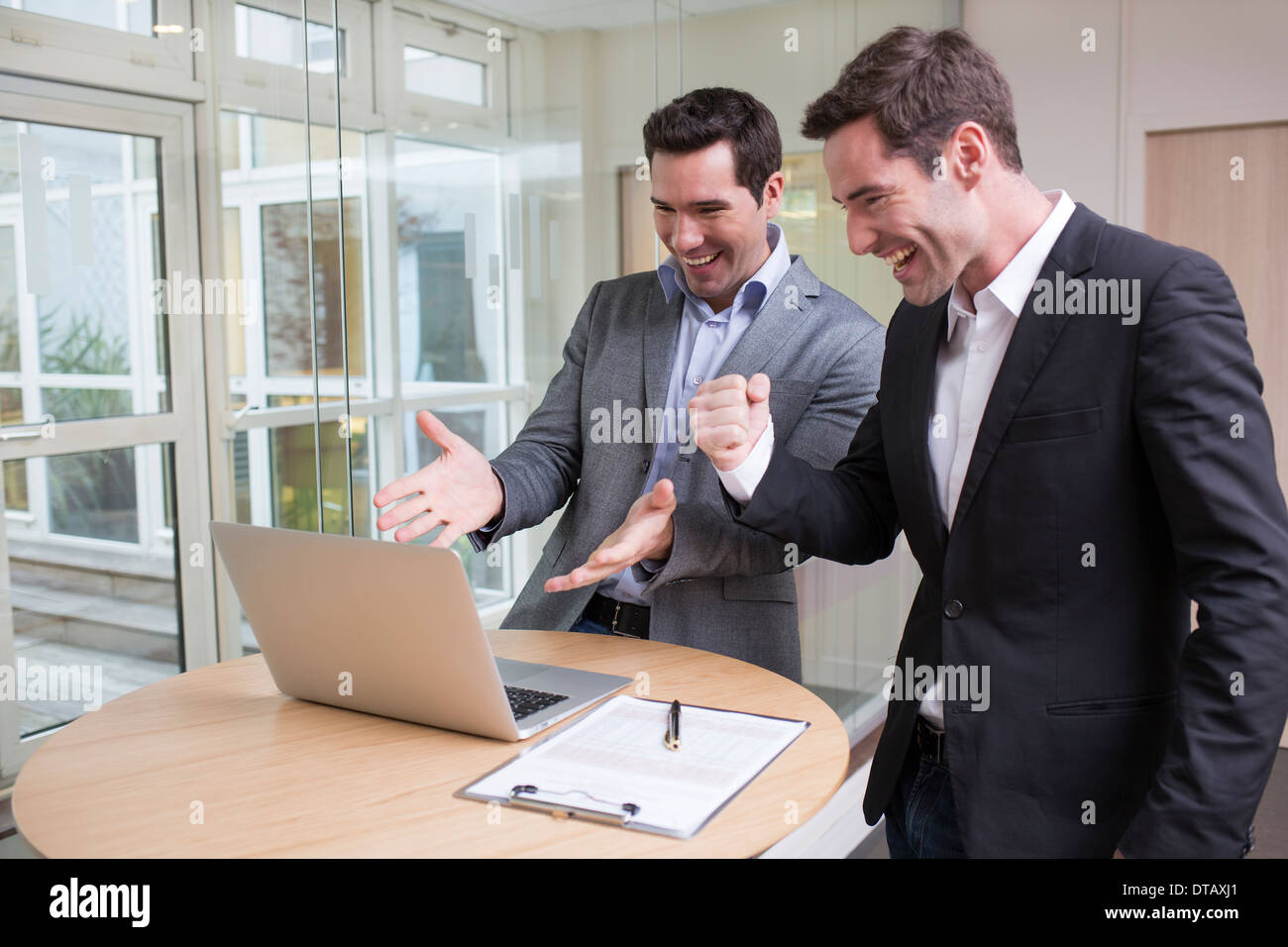 Erfolgreicher lächelnd Geschäftsmann im Büro, mit Arme nach oben Stockfoto