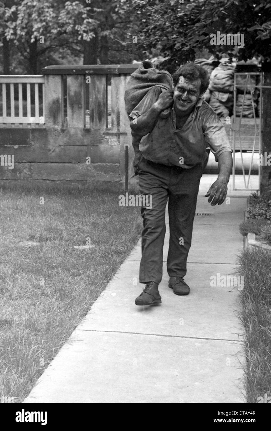 Kohle-Verkäufer tragen meschotschek voller Kohle, Berlin, DDR Stockfoto