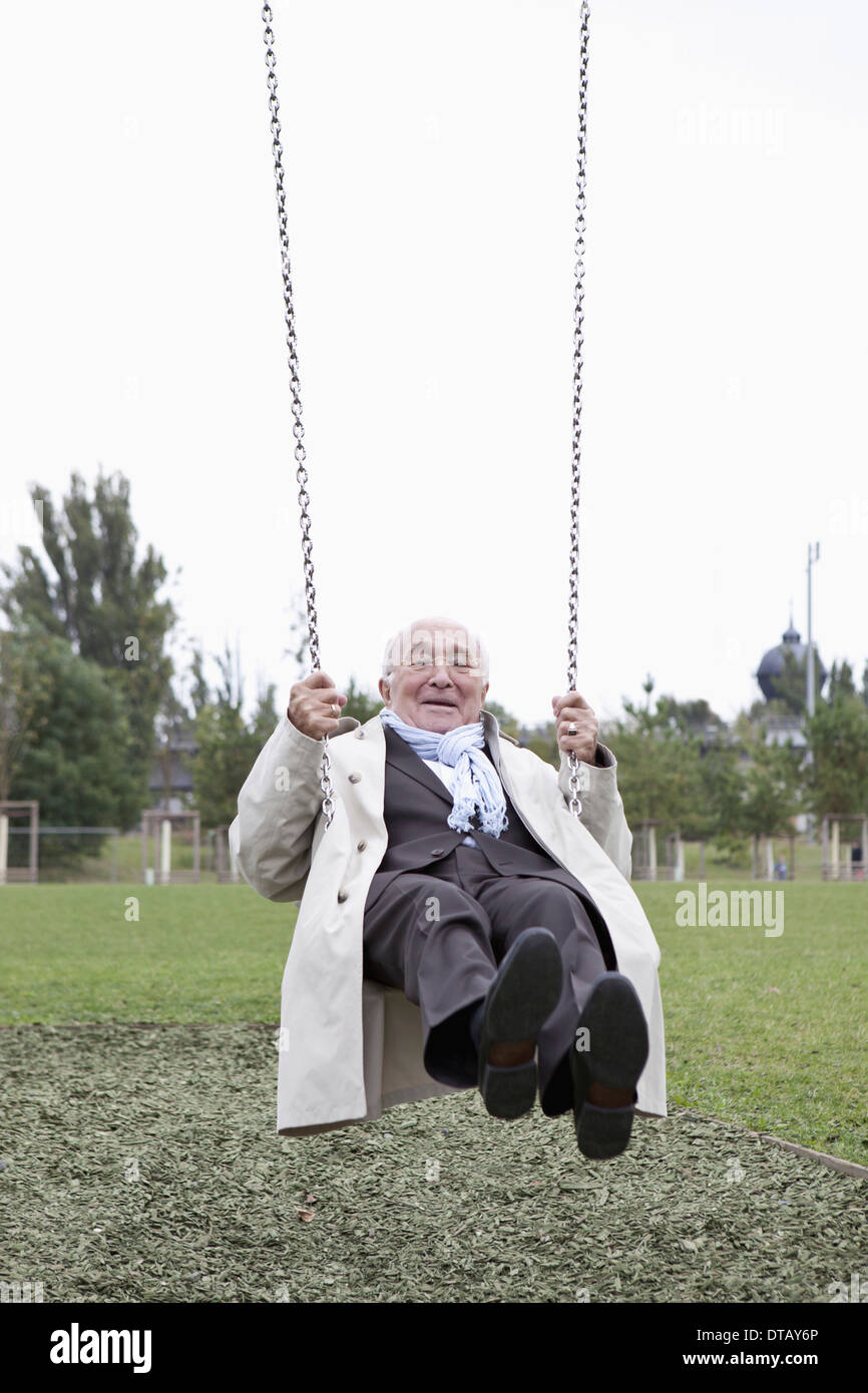 Senior woman schwingen im park Stockfoto