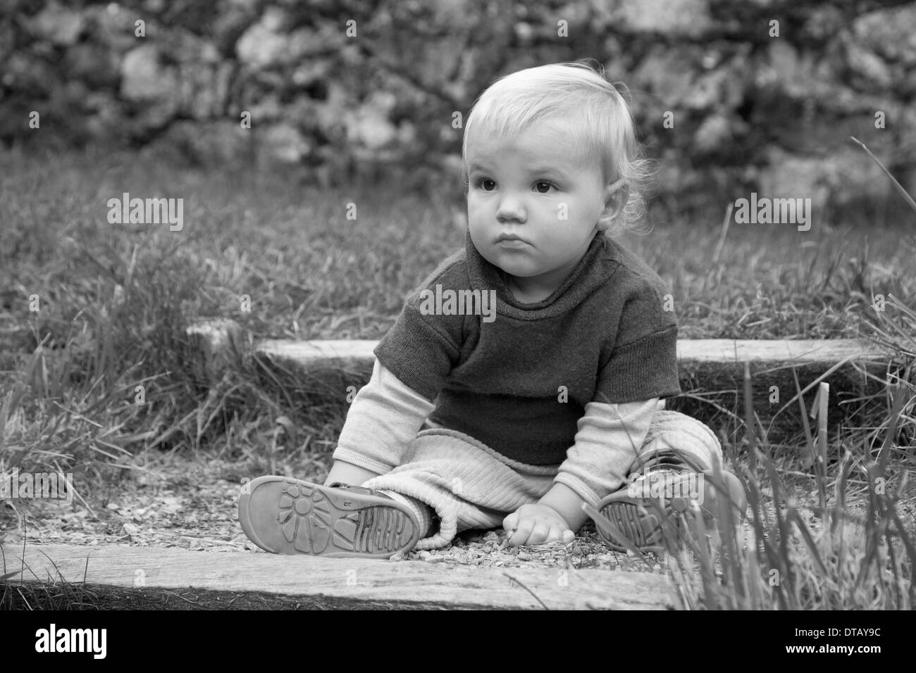 Baby Junge sitzt am Boden, wegschauen Stockfoto