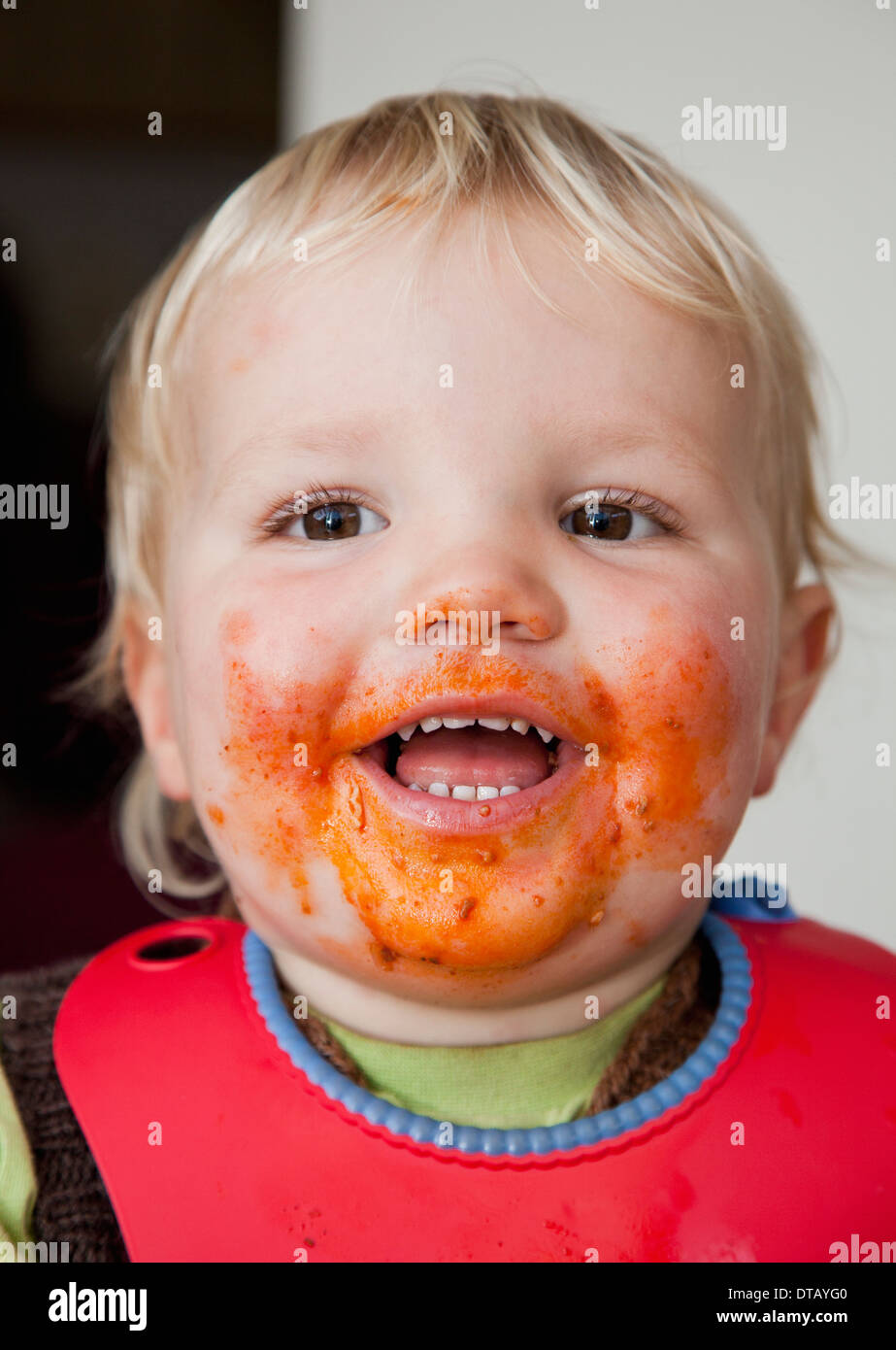 Einen lächelnden jungen mit Nahrung auf seinem Gesicht Nahaufnahme Stockfoto