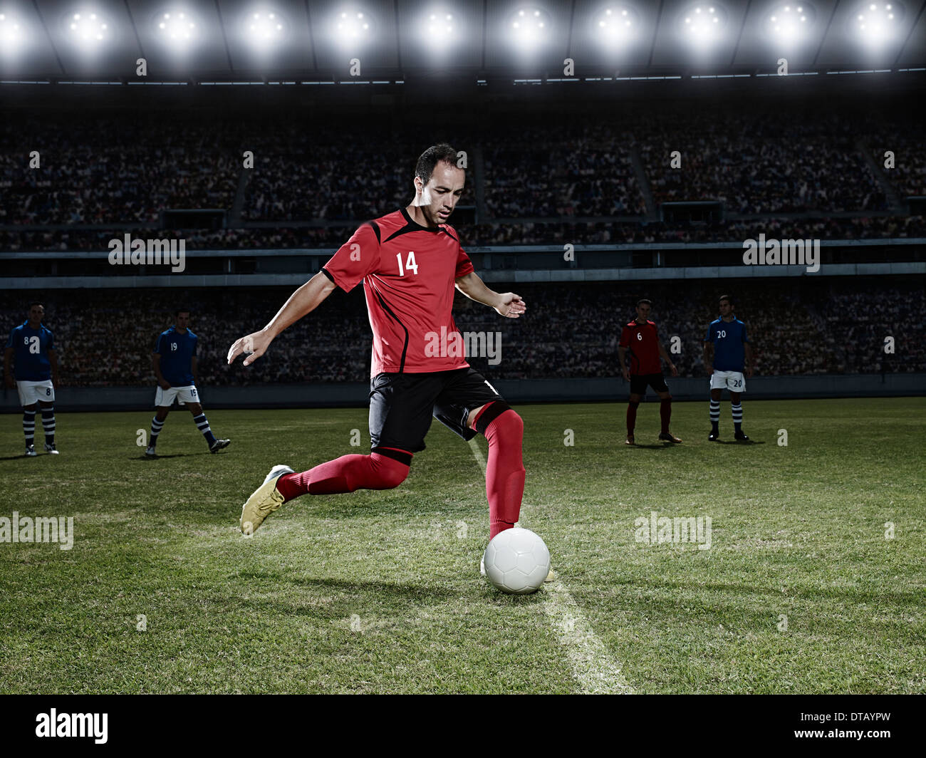 Fußball-Spieler treten Ball auf Feld Stockfoto