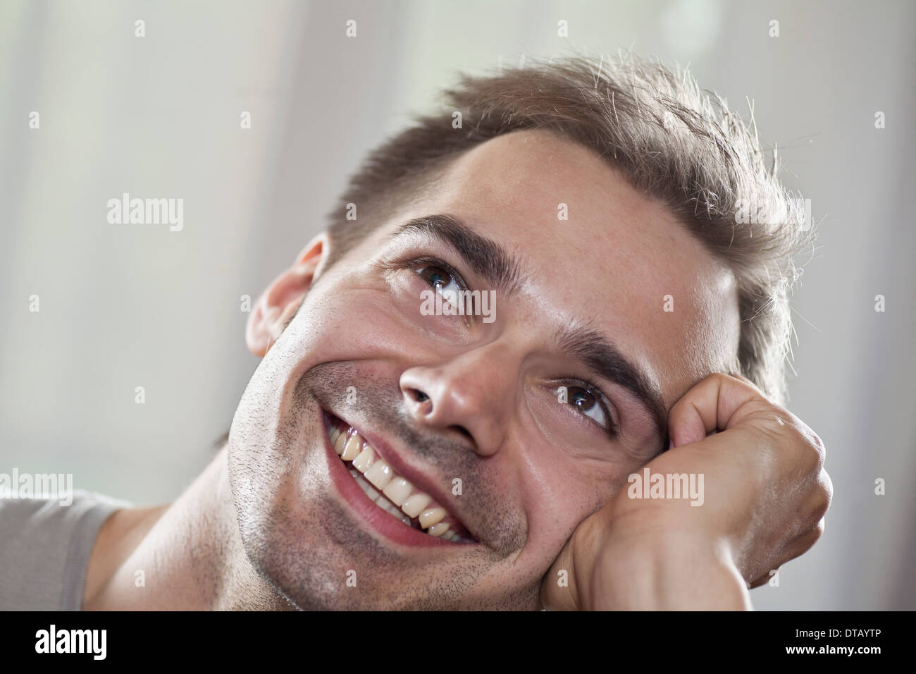 Junger Mann, nachschlagen und Lächeln auf den Lippen, Nahaufnahme Stockfoto