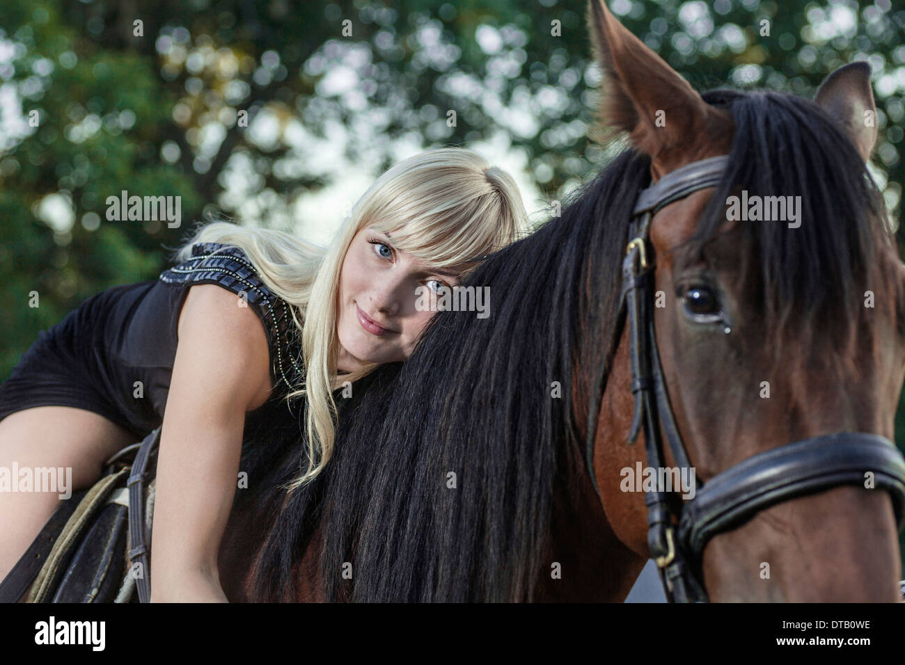 Junge Frau auf Pferd liegend Stockfoto