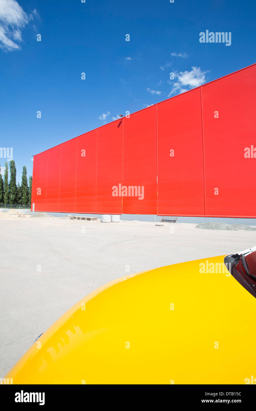 Gelbes Auto neben Rote Wand Stockfoto