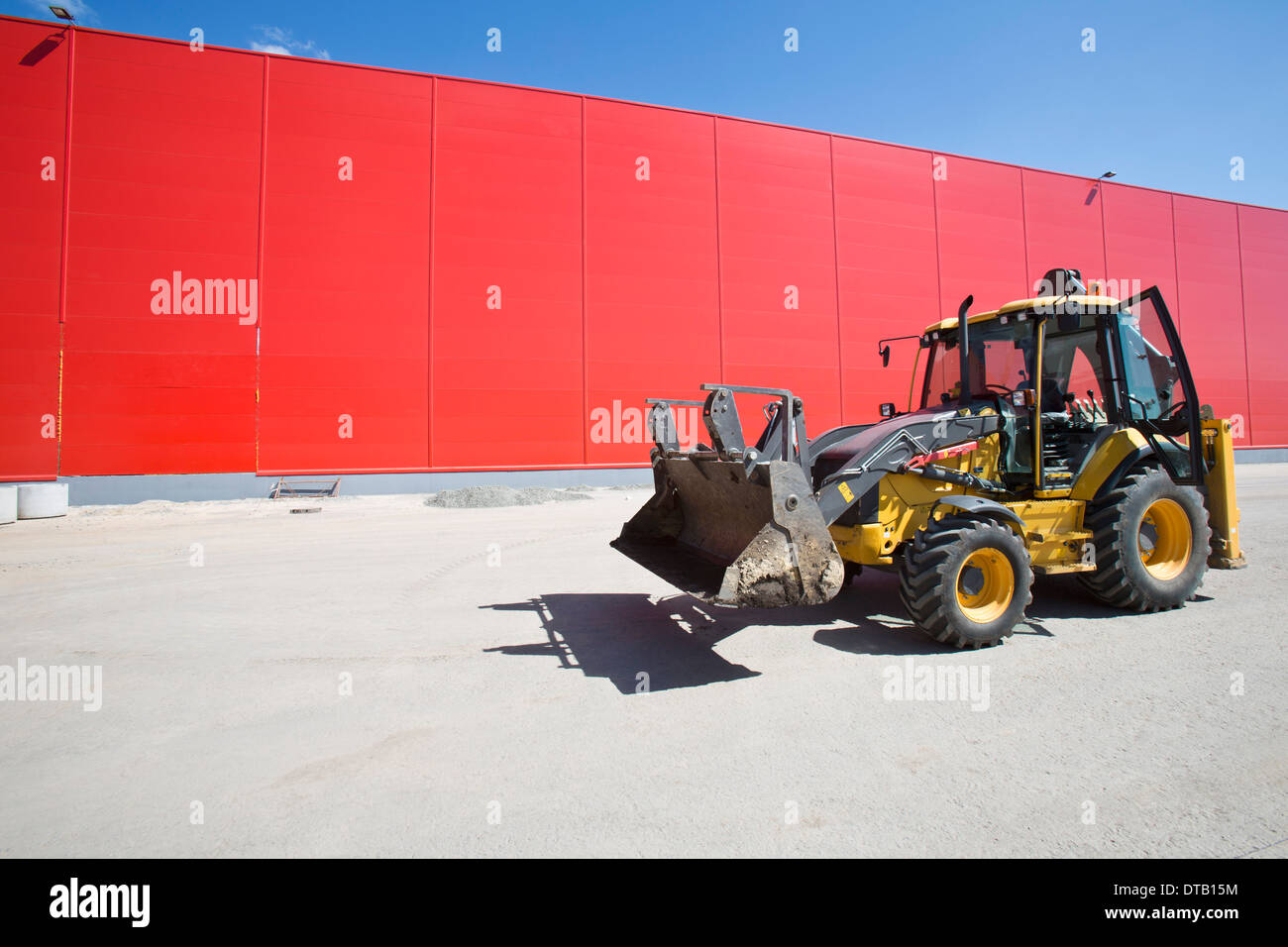 Planierraupe neben Rote Wand Stockfoto