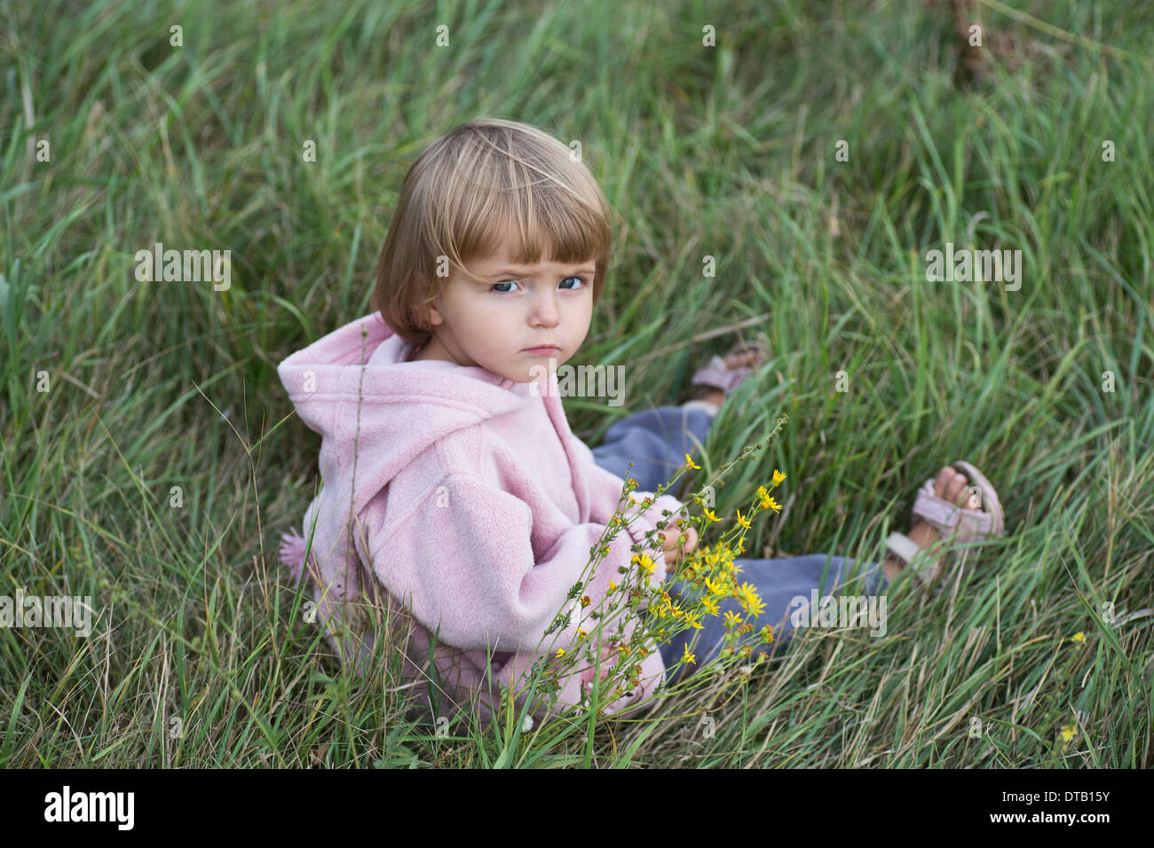 Mädchen sitzen auf dem Rasen, Porträt Stockfoto