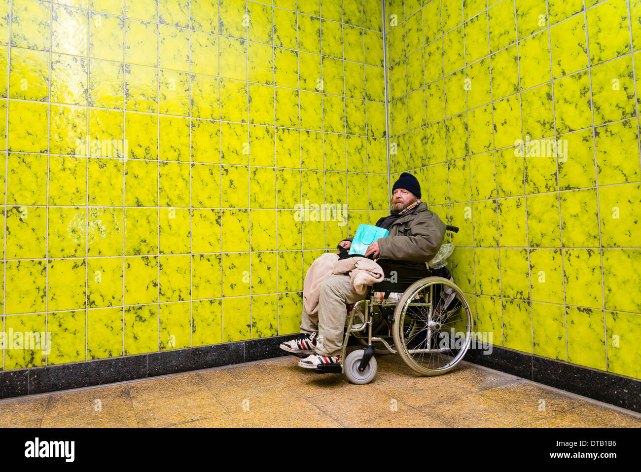 Ein Obdachloser Rollstuhlfahrer sitzt in "seine" Ecke, wo lebt er in einer u-Bahnstation. Stockfoto