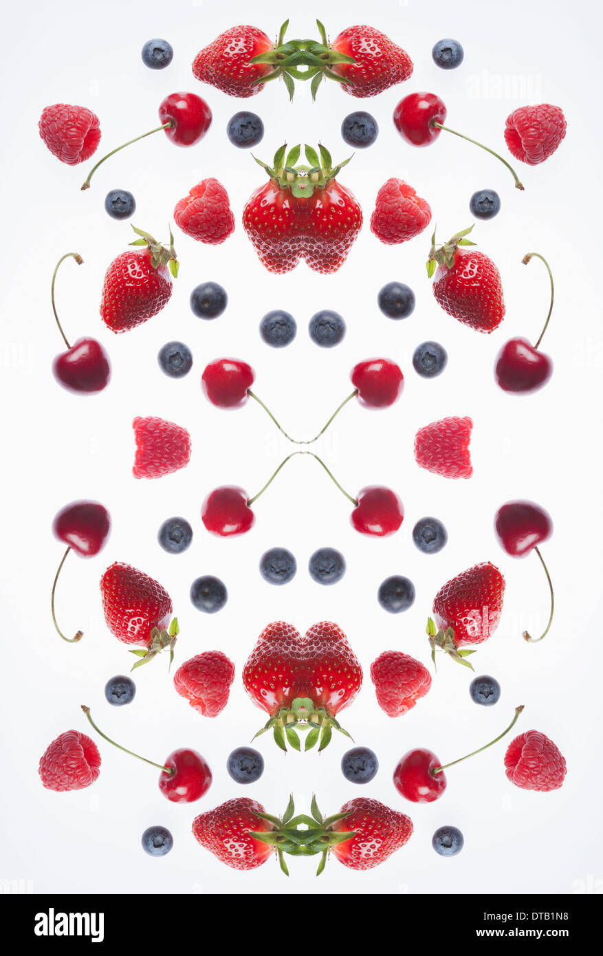 Eine digitale Zusammensetzung der gespiegelten Bildern der Anordnung der verschiedenen Beeren und Kirschen Stockfoto