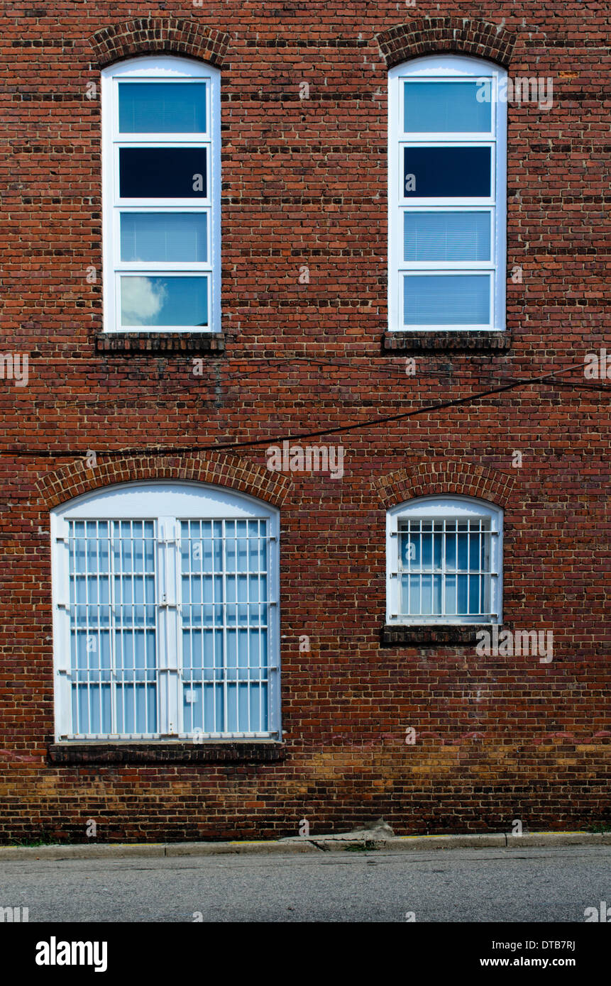 Außen von einem alten Ziegel industrielle Fabrikgebäude mit bunten Fenstern. Stockfoto