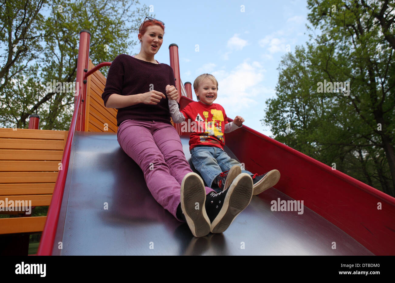 Berlin, Deutschland, eine Mutter mit ihrem Sohn auf einer Folie Stockfoto