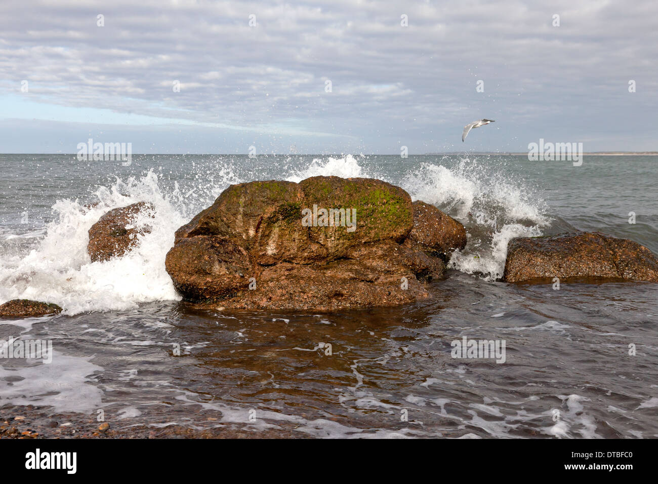 Welle bricht auf einem großen Felsen an der Küste der Halbinsel in Thy Dänemark Stockfoto