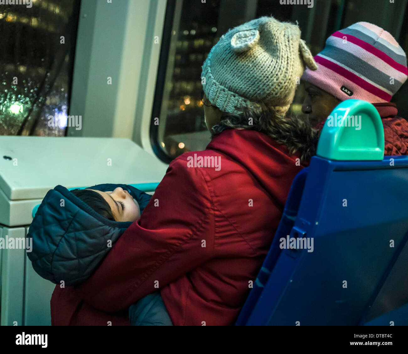 Heimwärts gebunden Sie-müdes schlafendes Kind mit zwei Frauen auf der DLR Docklands Light Railway - London, UK Stockfoto