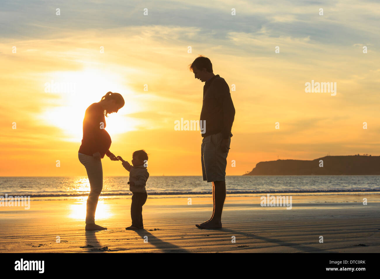 Familie und Kleinkind Sohn spielt am Strand bei Sonnenuntergang, San Diego, Kalifornien, USA Stockfoto