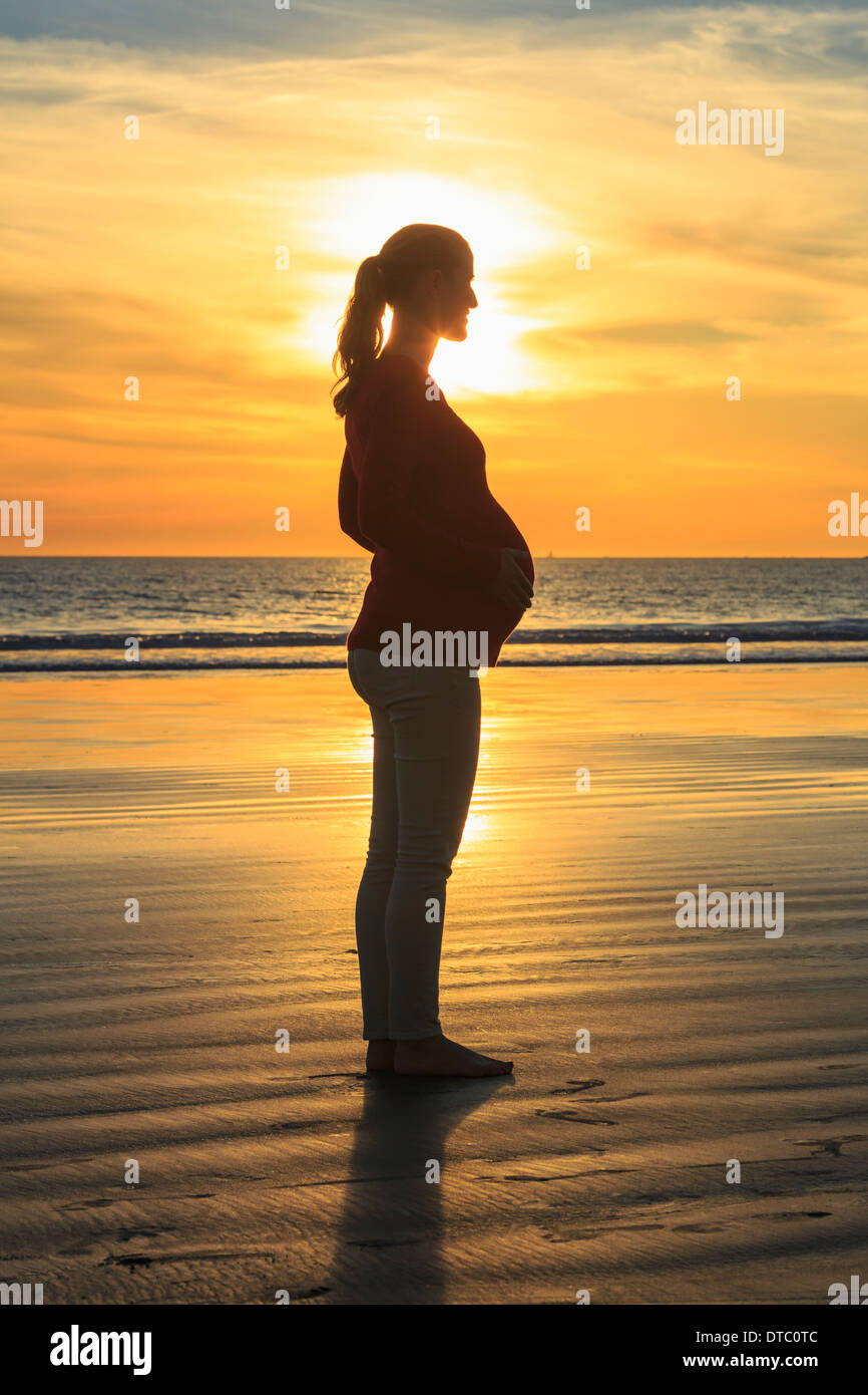 Schwanger Mitte Erwachsene Frau am Strand bei Sonnenuntergang, San Diego, Kalifornien, USA Stockfoto
