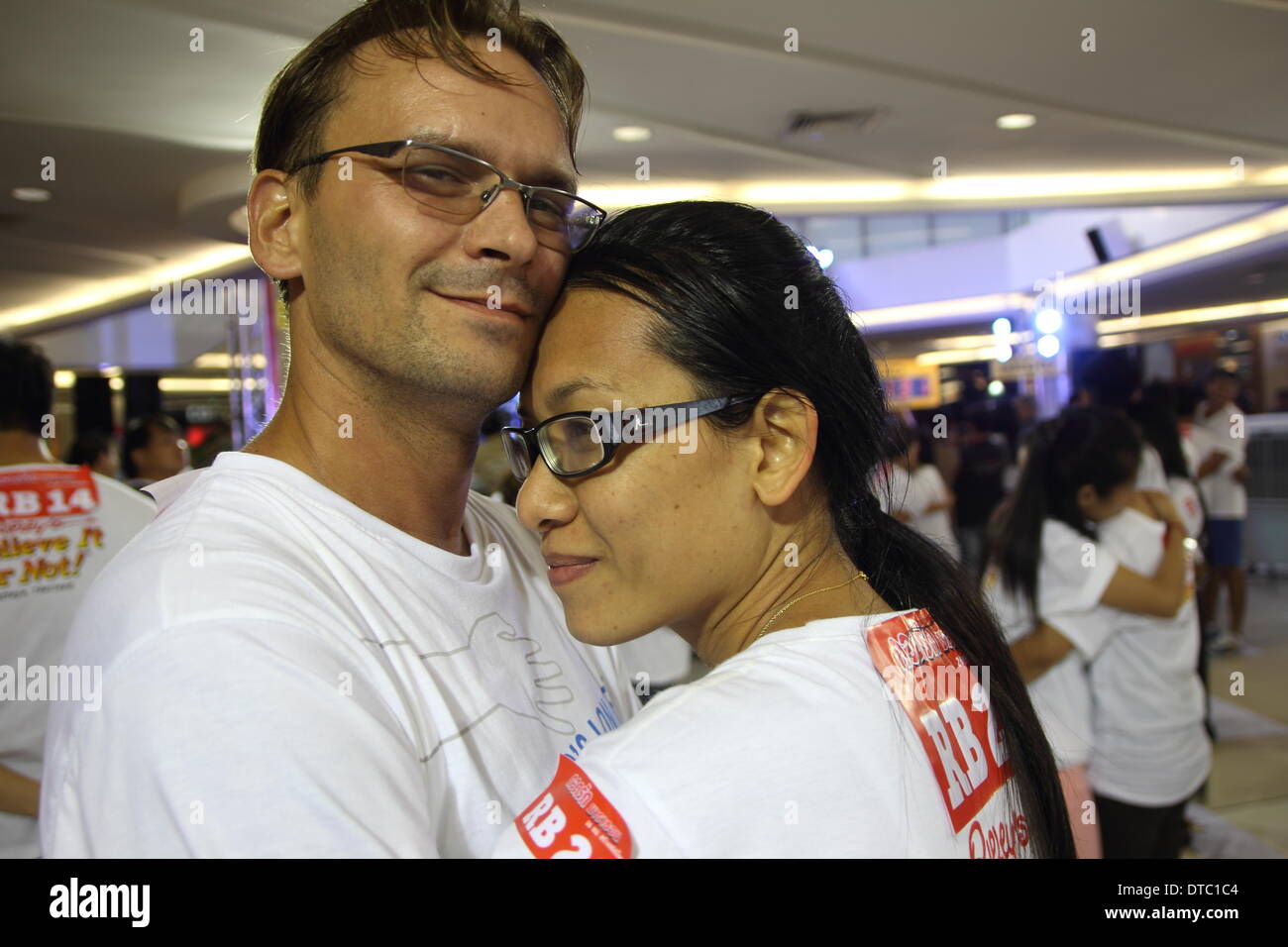 Pattaya, Thailand. 14 Februar 2014.  Ein paar deutsche Jens Hotze und Thai Siriporn Buakla umarmen einander in einem Versuch, die Guinness-Rekorde für den längsten Marathon umarmt im Rahmen der anstehenden Valentinstag feiern in Pattaya zu brechen. Die "Welten längste umarmt Marathon" am Valentinstag in Pattaya organisiert von Ripleys Believe It or Not. Sechsundzwanzig Paare gemacht die neue Welten längste umarmt Marathon "bei 26 Stunden 26 Minuten 26 Sekunden. Bildnachweis: John Vincent/Alamy Live-Nachrichten Stockfoto