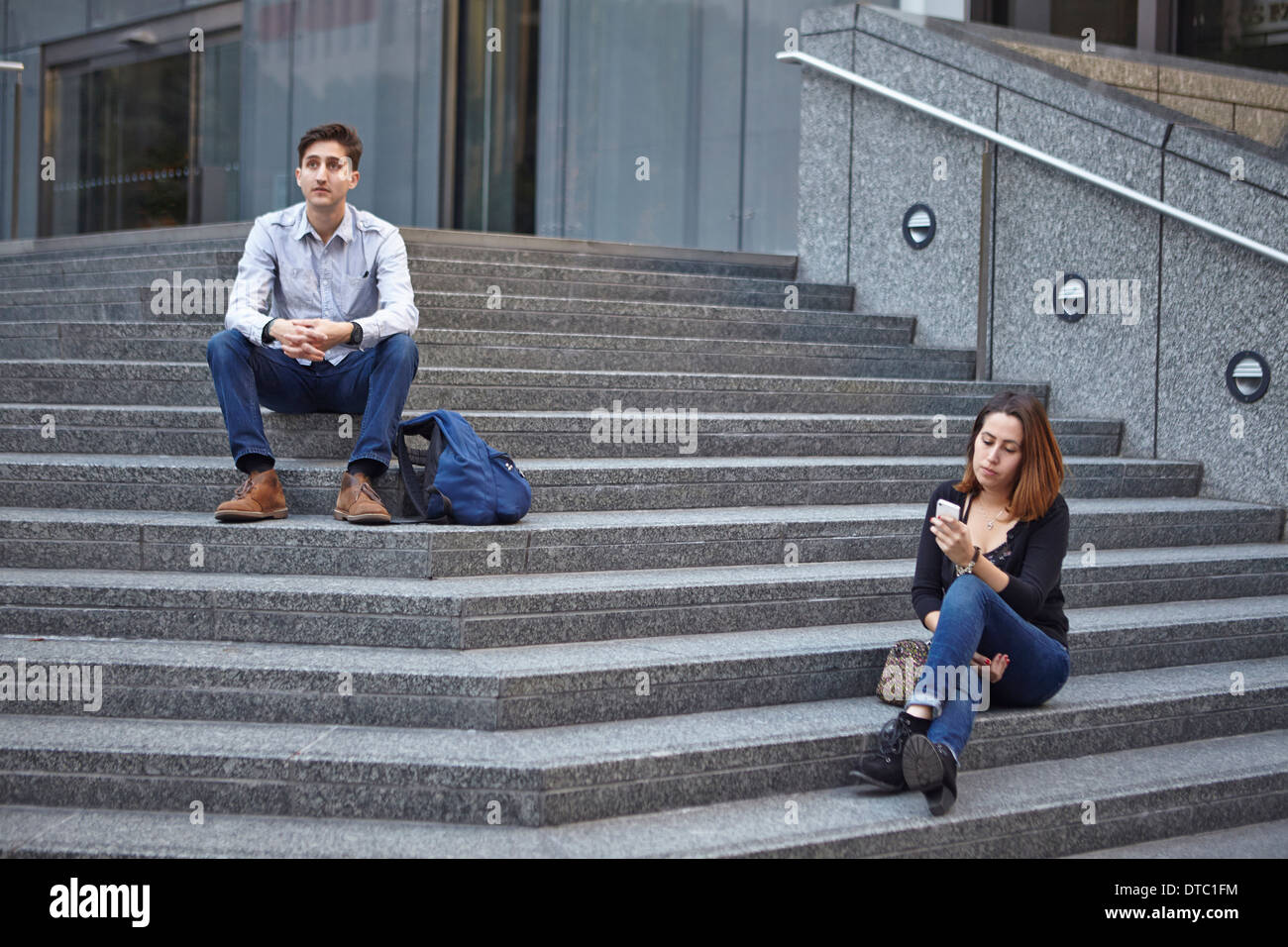 Unglückliche paar auseinander sitzen auf Stufen Stockfoto