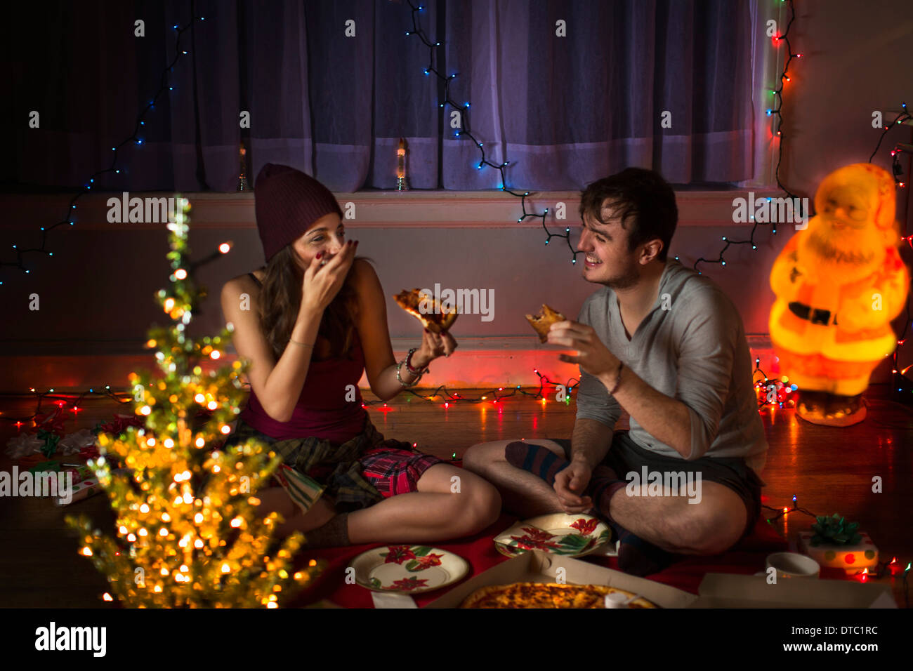 Junges Paar genießen Pizza zu Weihnachten Stockfoto