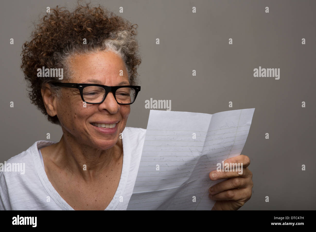 Studioportrait glücklich senior Frau liest einen Brief Stockfoto