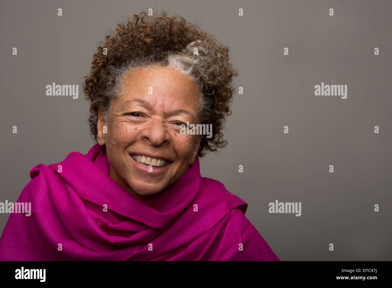 Studioportrait glücklich senior Frau in rosa Schal Stockfoto