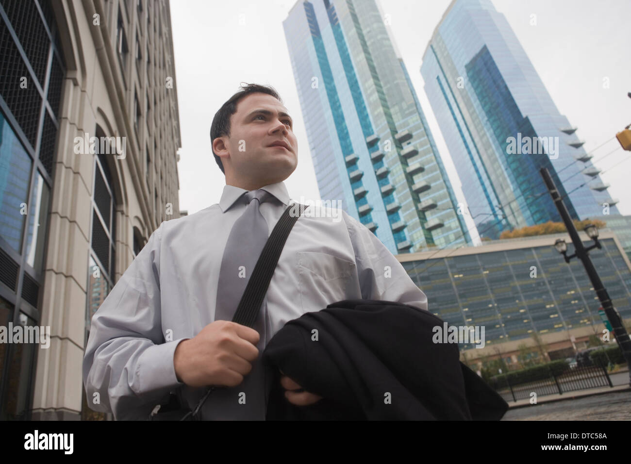 Geschäftsmann in Stadt umgeben von Wolkenkratzern Stockfoto