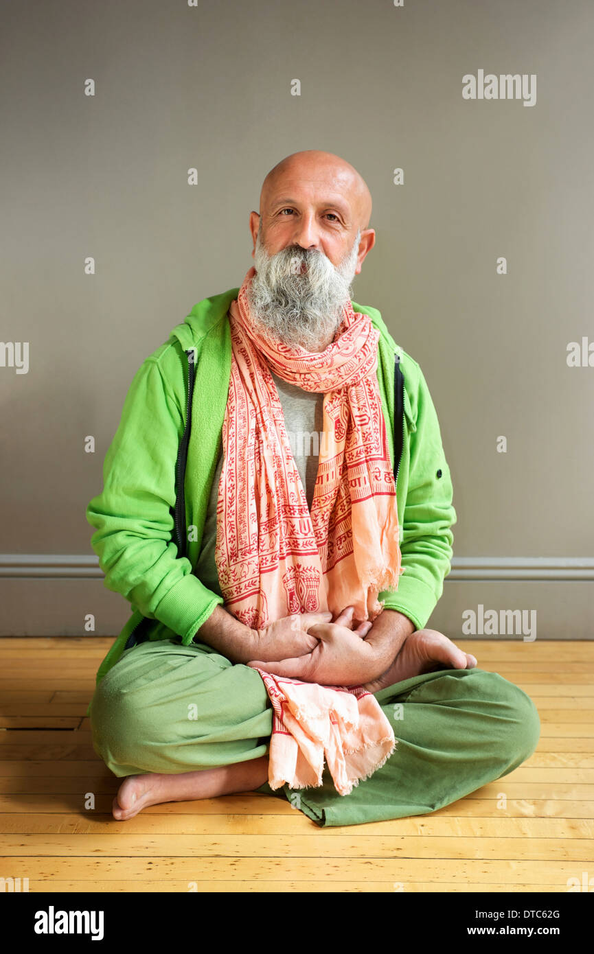 Porträt von reifer Mann sitzen in Lotus-Pose auf Boden Stockfoto