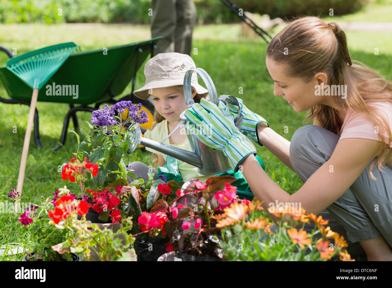 Mutter und Tochter, die Bewässerung von Pflanzen im Garten Stockfoto