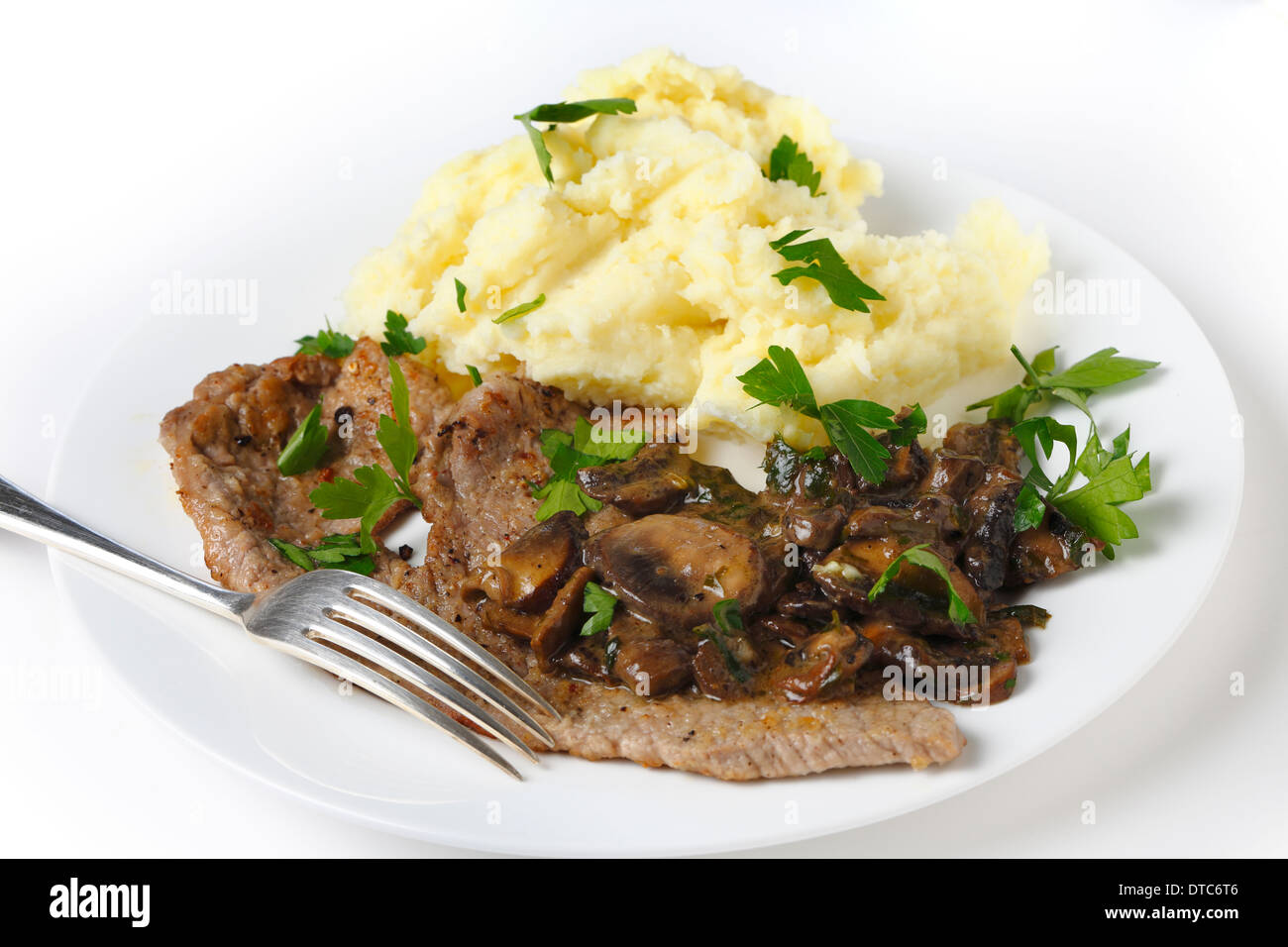 Gebratene Kalbsschnitzel mit Kartoffelpüree und ein cremiger Pilzsauce serviert Stockfoto