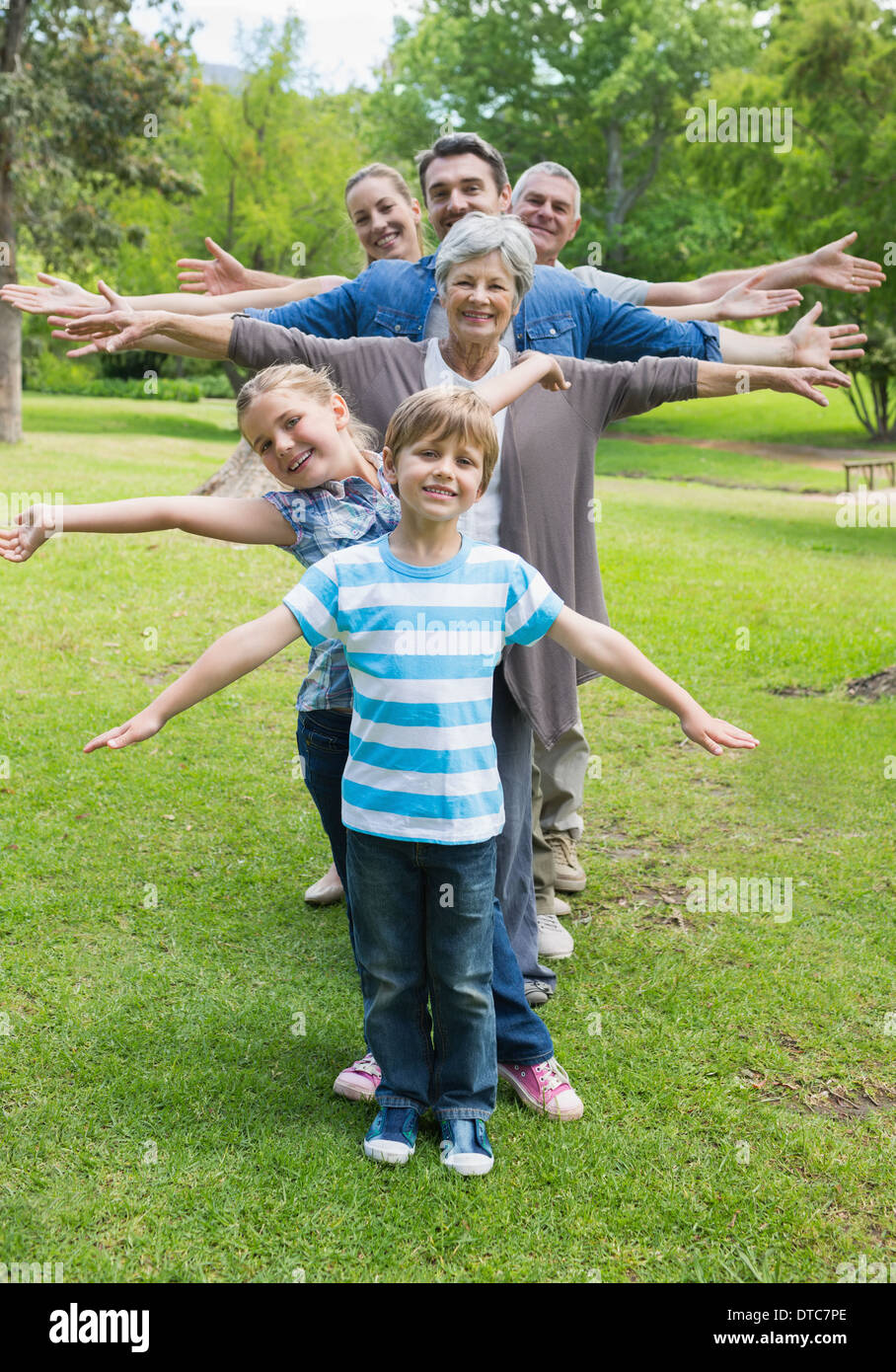 Großfamilie stehend in Reihe mit ausgestreckten im park Stockfoto