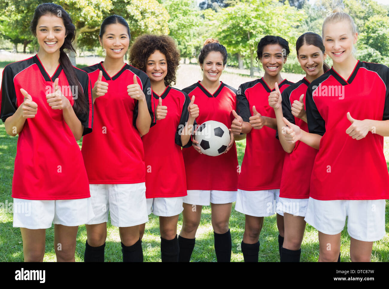 Weibliche Fußball team gestikulieren Daumen im park Stockfoto