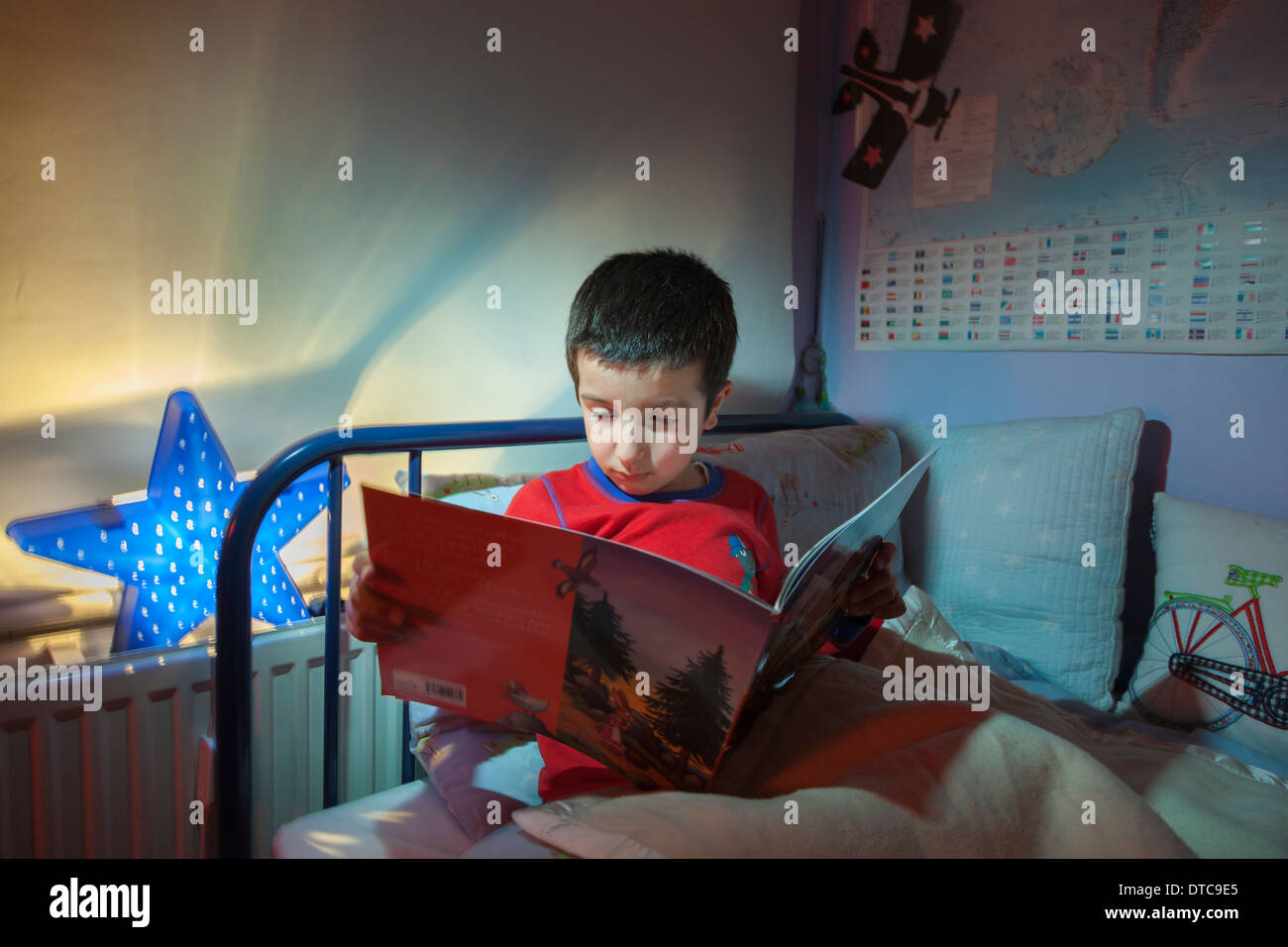 Kleiner Junge, liest eine Gutenachtgeschichte in seinem Bett Stockfoto
